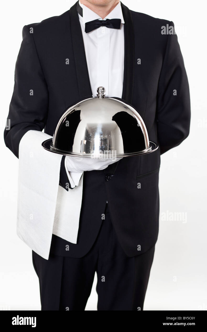 A butler holding a domed tray Stock Photo