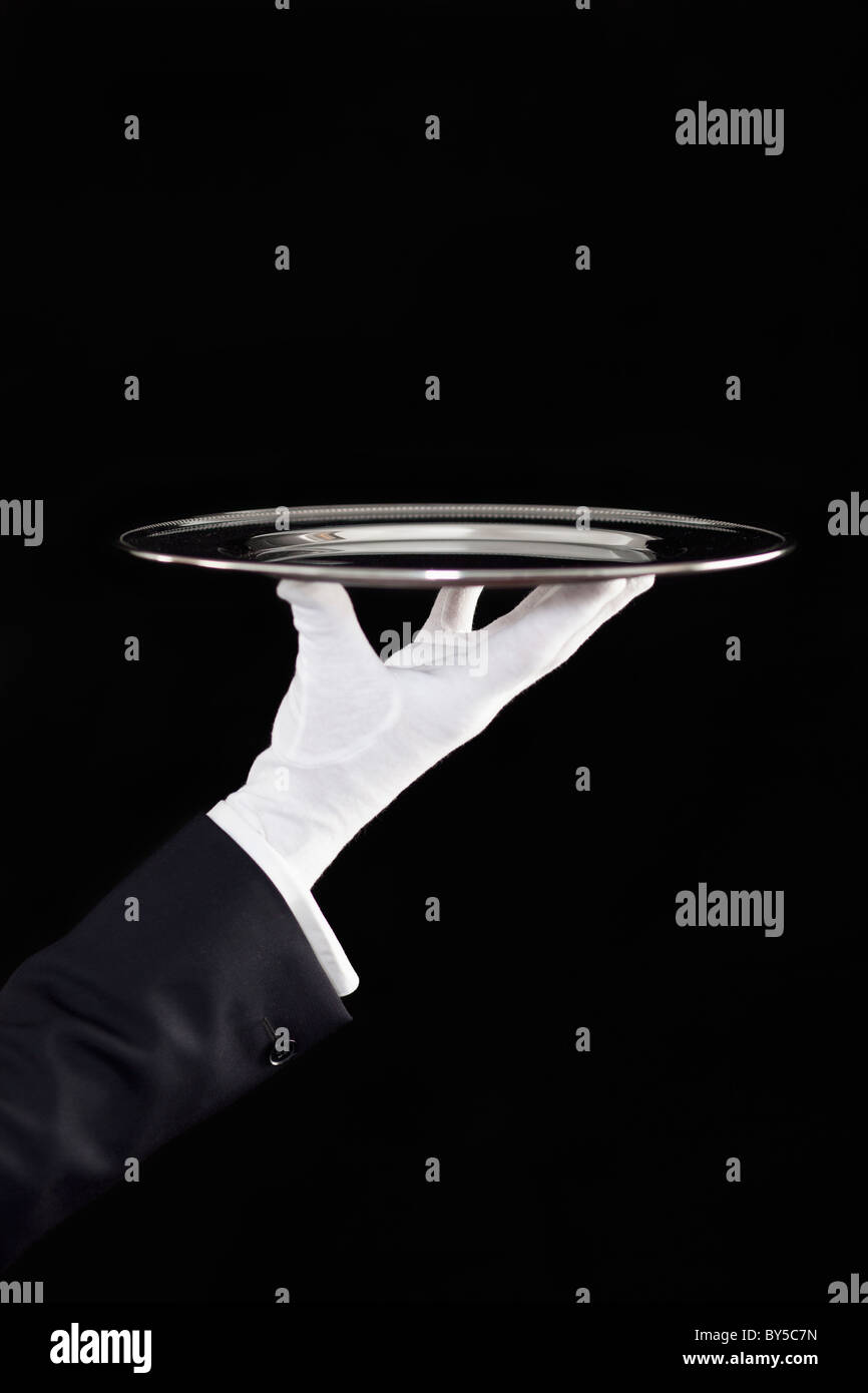A butler presenting an empty silver tray, focus on hand Stock Photo