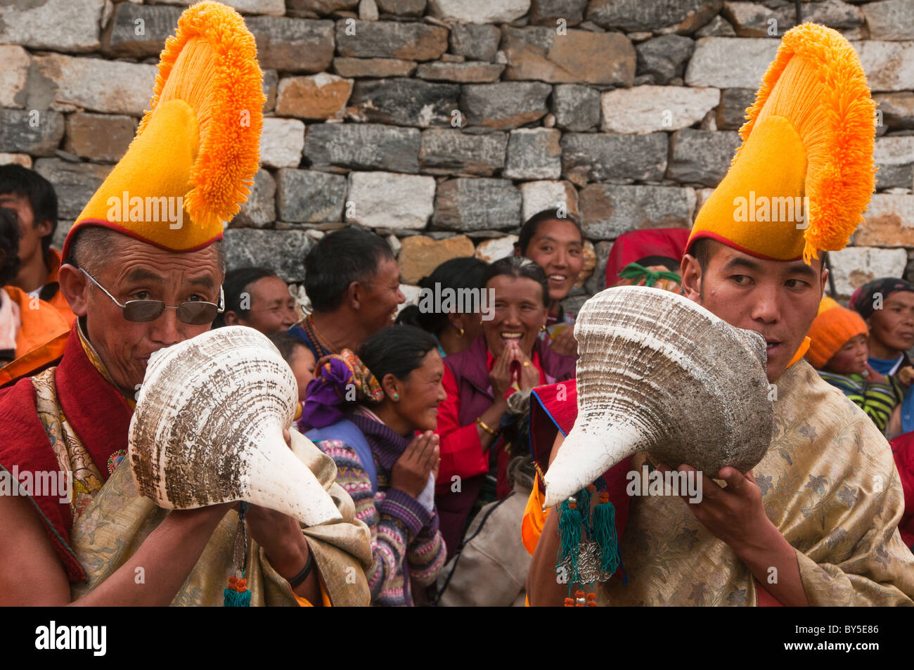 yellow hat Gelugpa monks blowing conch shells at the Mani Rimdu