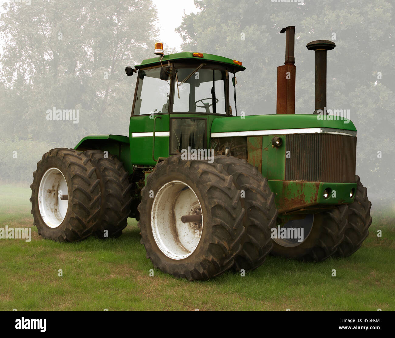 green and white tractor standing alone Stock Photo - Alamy