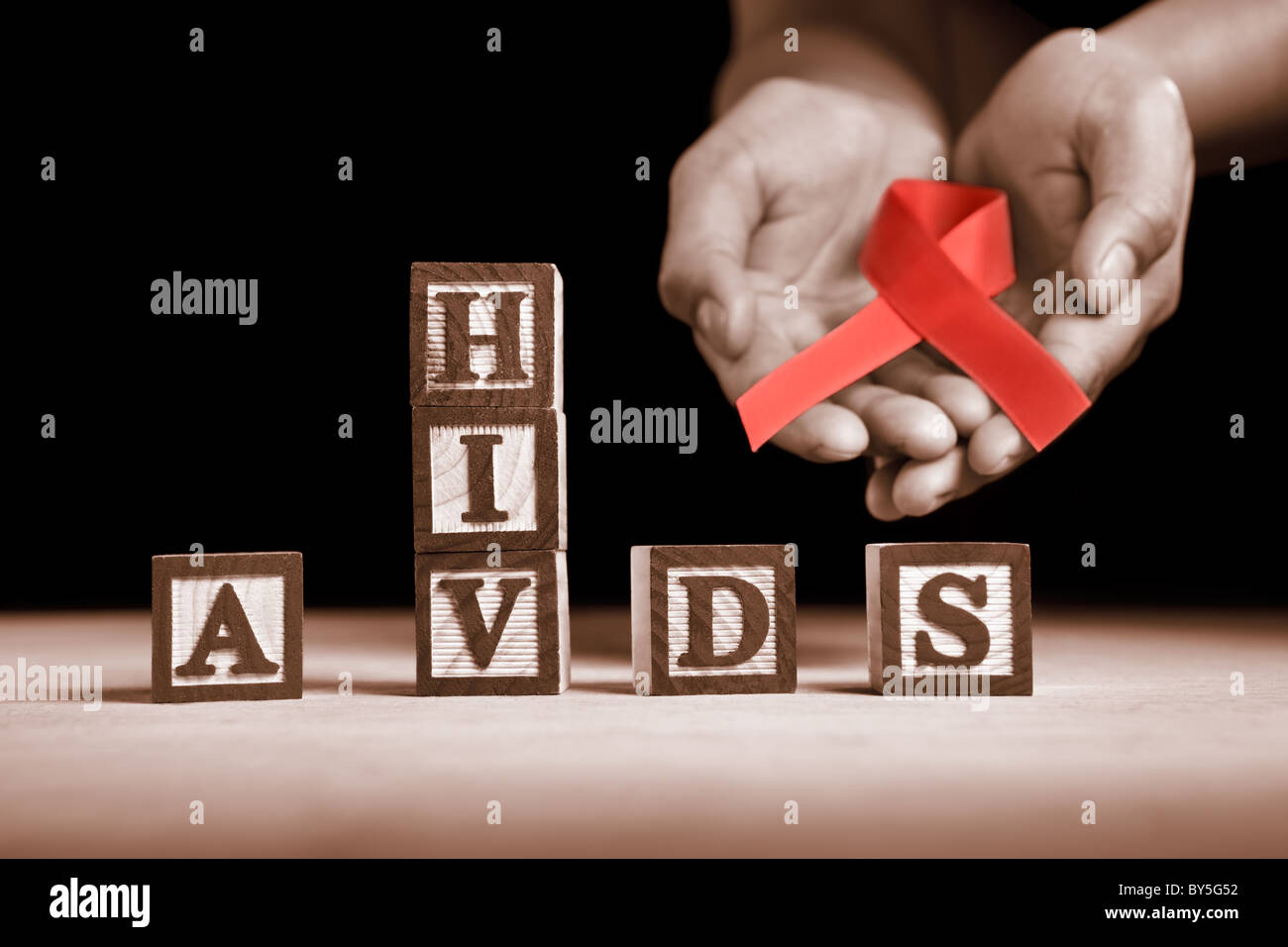 Hand holding red ribbon on back of HIV-AIDS letter blocks Stock Photo ...