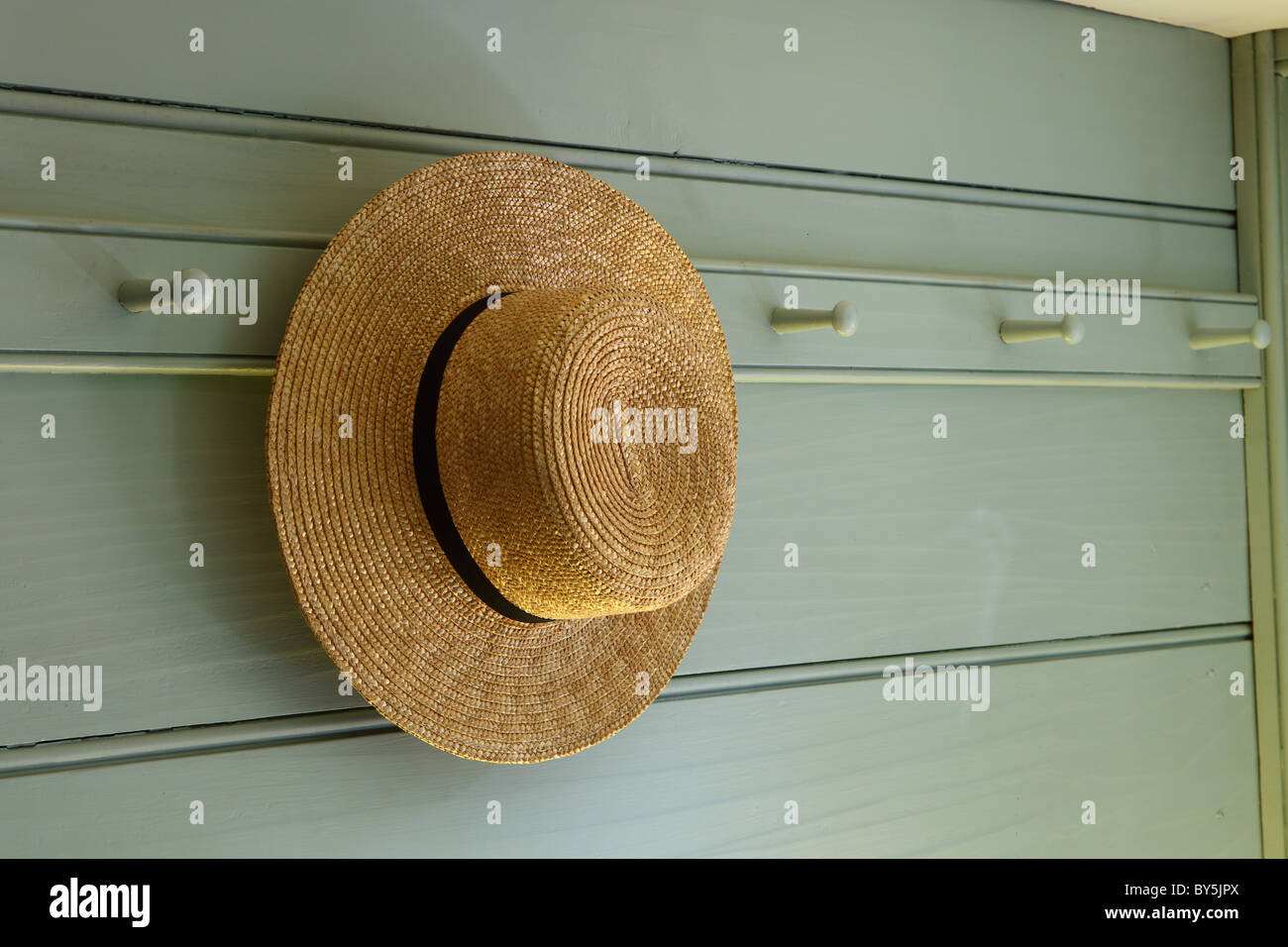 A straw hat hanging on a peg in a reproduction colonial style house