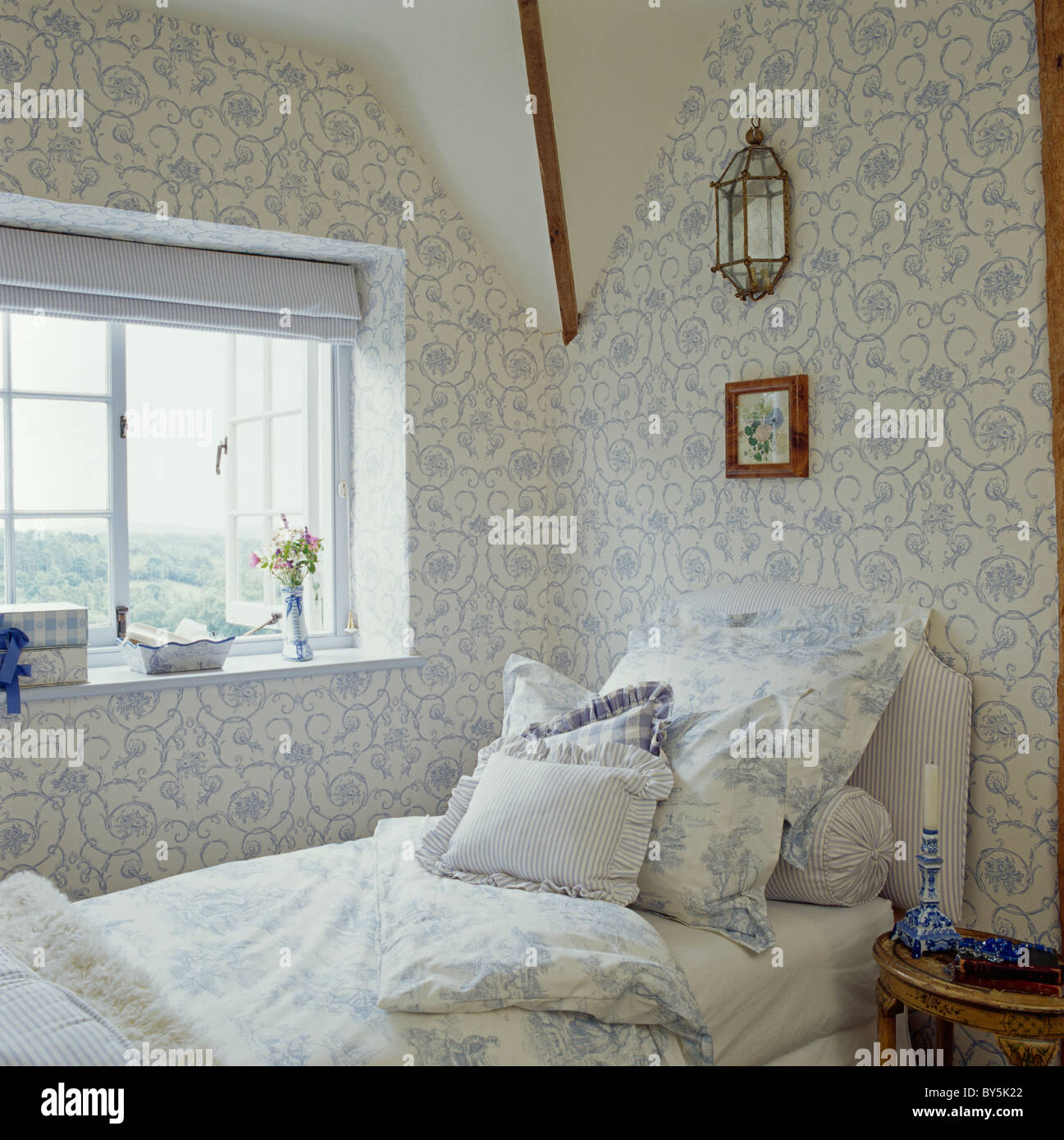 Blue+white floral wallpaper in cottage attic bedroom with matching blue