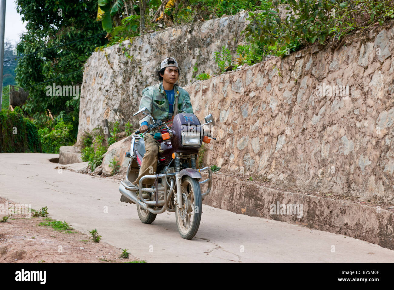 Man on motorcycle Jinuo Luoke (Jinuo Shan), Jinghong, Xishuangbanna, Yunnan Province, People's Republic of China. JMH4307 Stock Photo