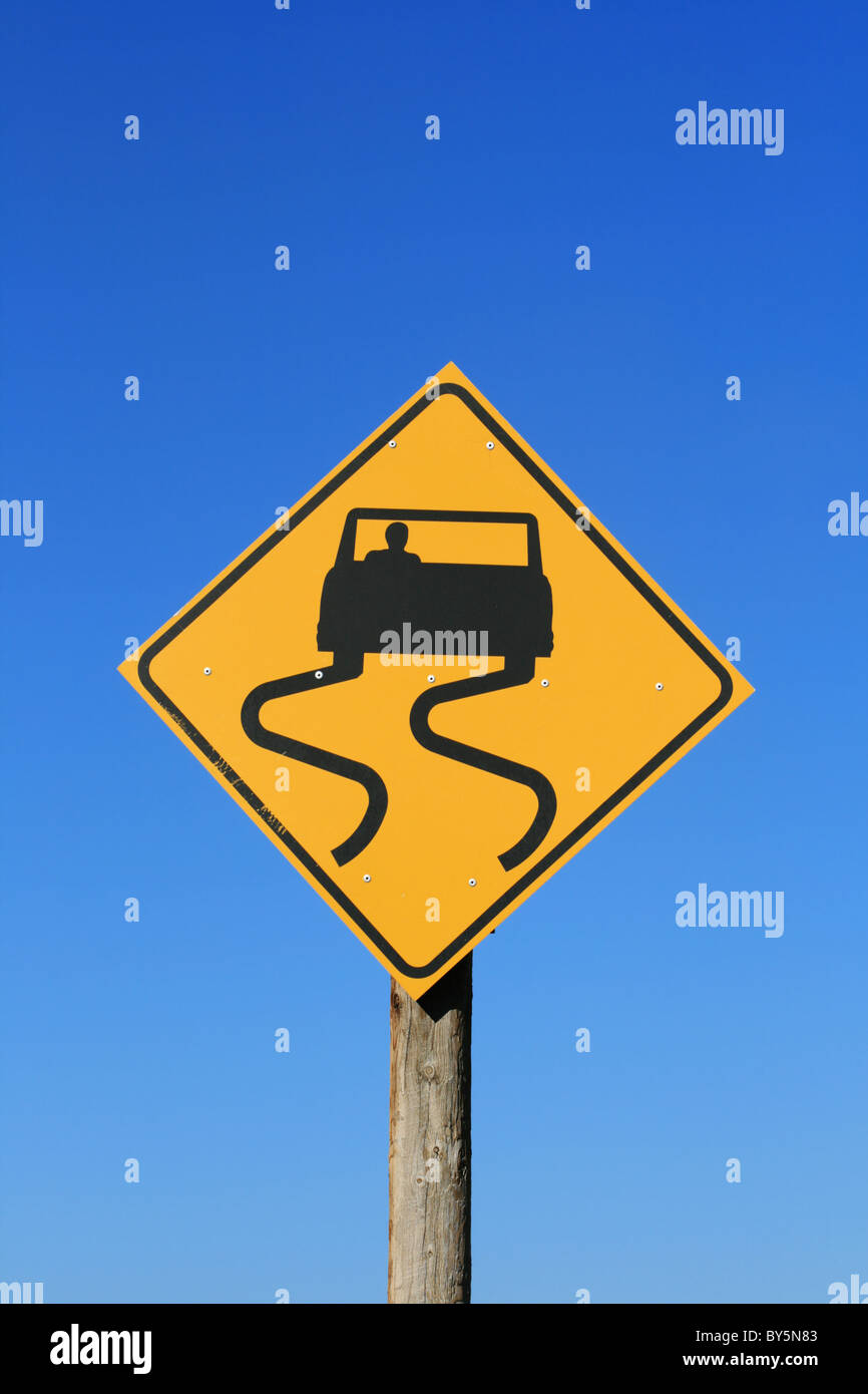 Slippery Road Sign With Car And Skid Marks In Black On Yellow With Blue Sky Background Stock Photo Alamy