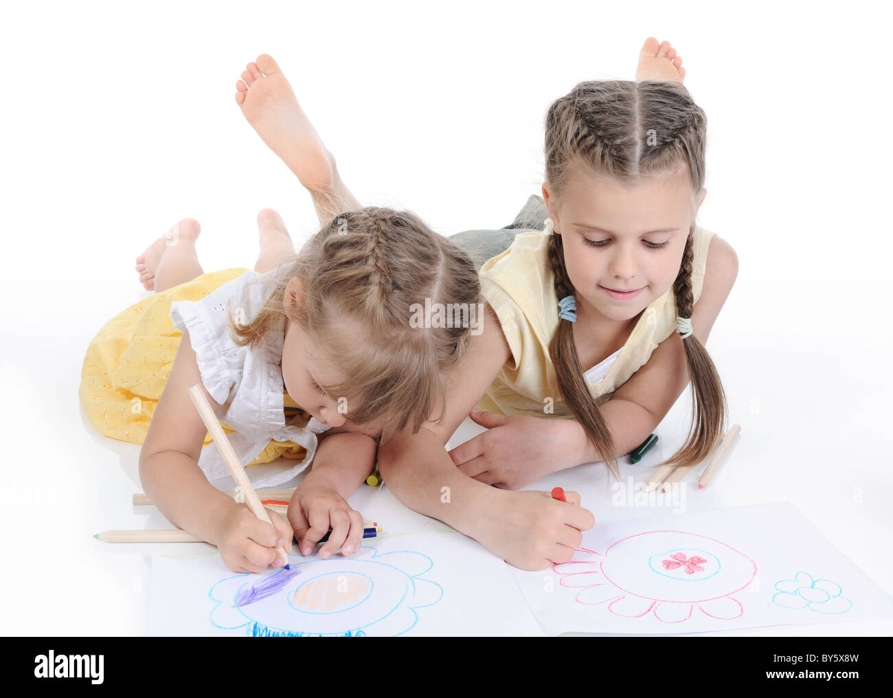 Two sisters draw on the album. Stock Photo