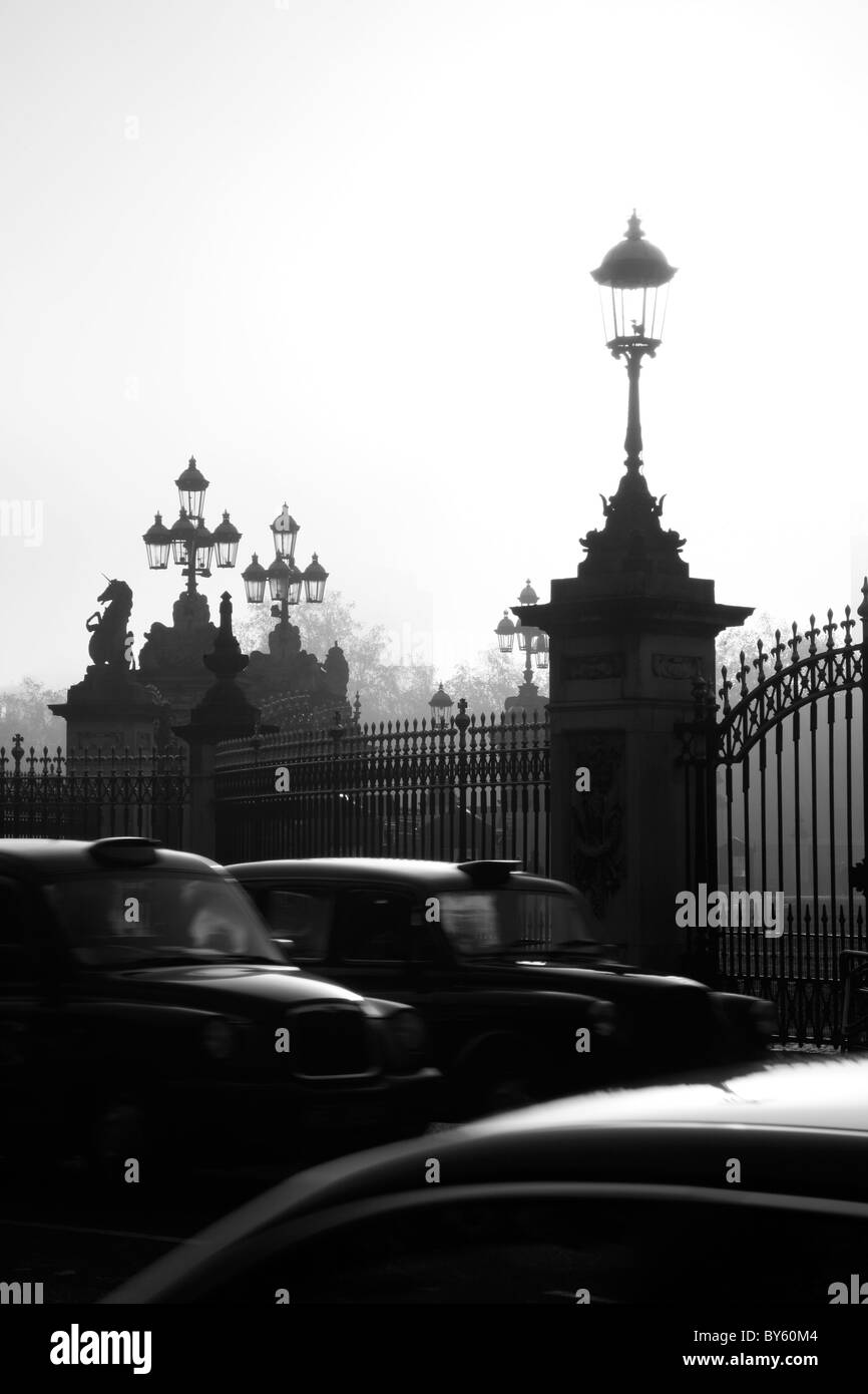 Taxis driving past gates of Buckingham Palace on Buckingham Palace Forecourt, St James's, London, UK Stock Photo