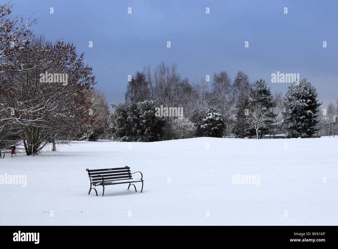 Deserted bench in snow, Sadler's Ride, Hurst Park, East Molesey, Surrey, England, Great Britain, United Kingdom UK, Europe Stock Photo