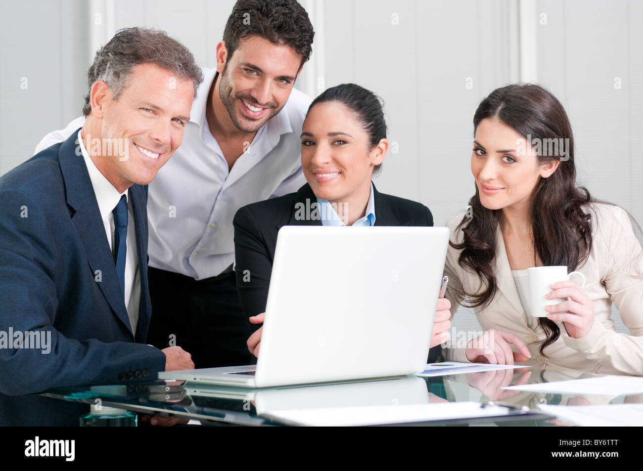 Satisfied business team smiling and looking at camera in office Stock ...