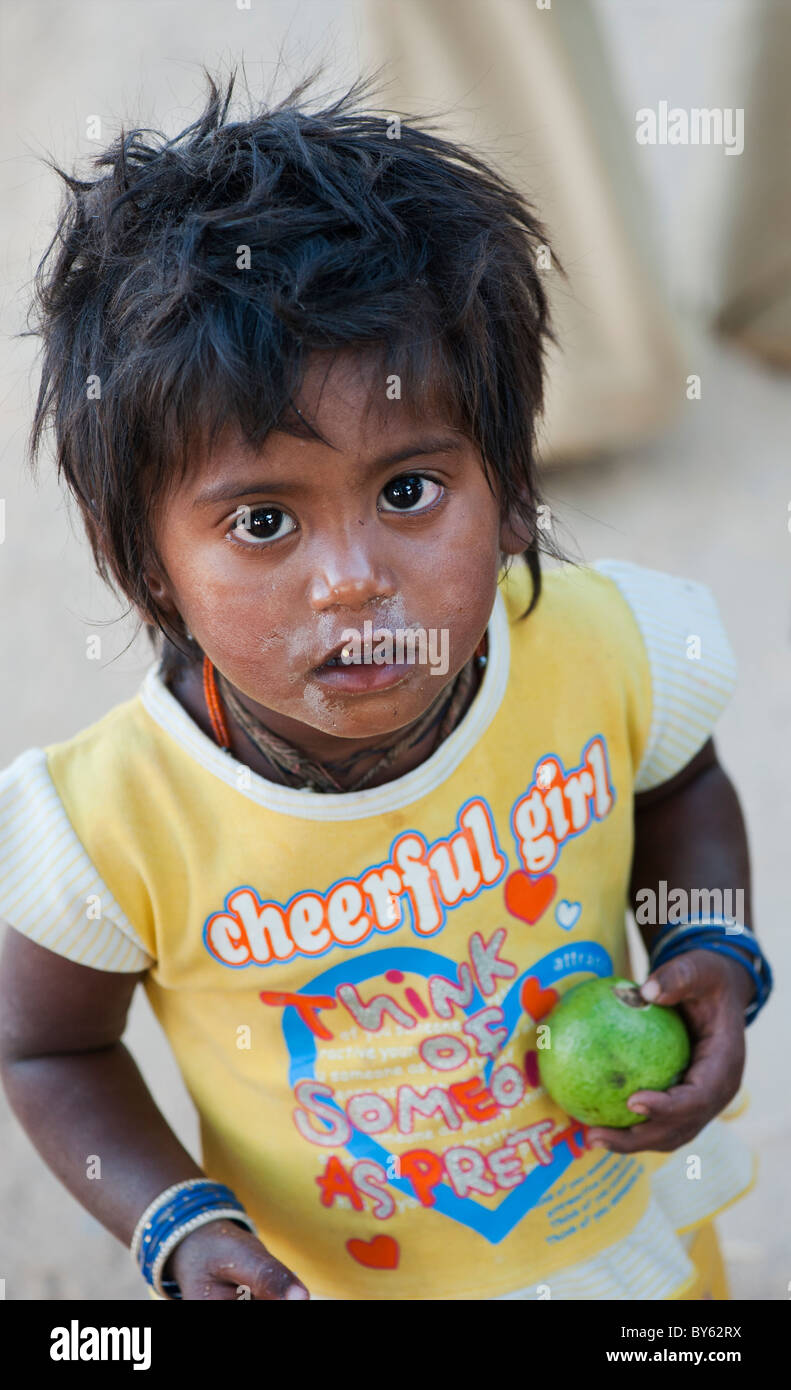 Young poor lower caste Indian street girl wearing a t shirt that says, 'cheerful girl think of someone as pretty'. Andhra Pradesh, India Stock Photo