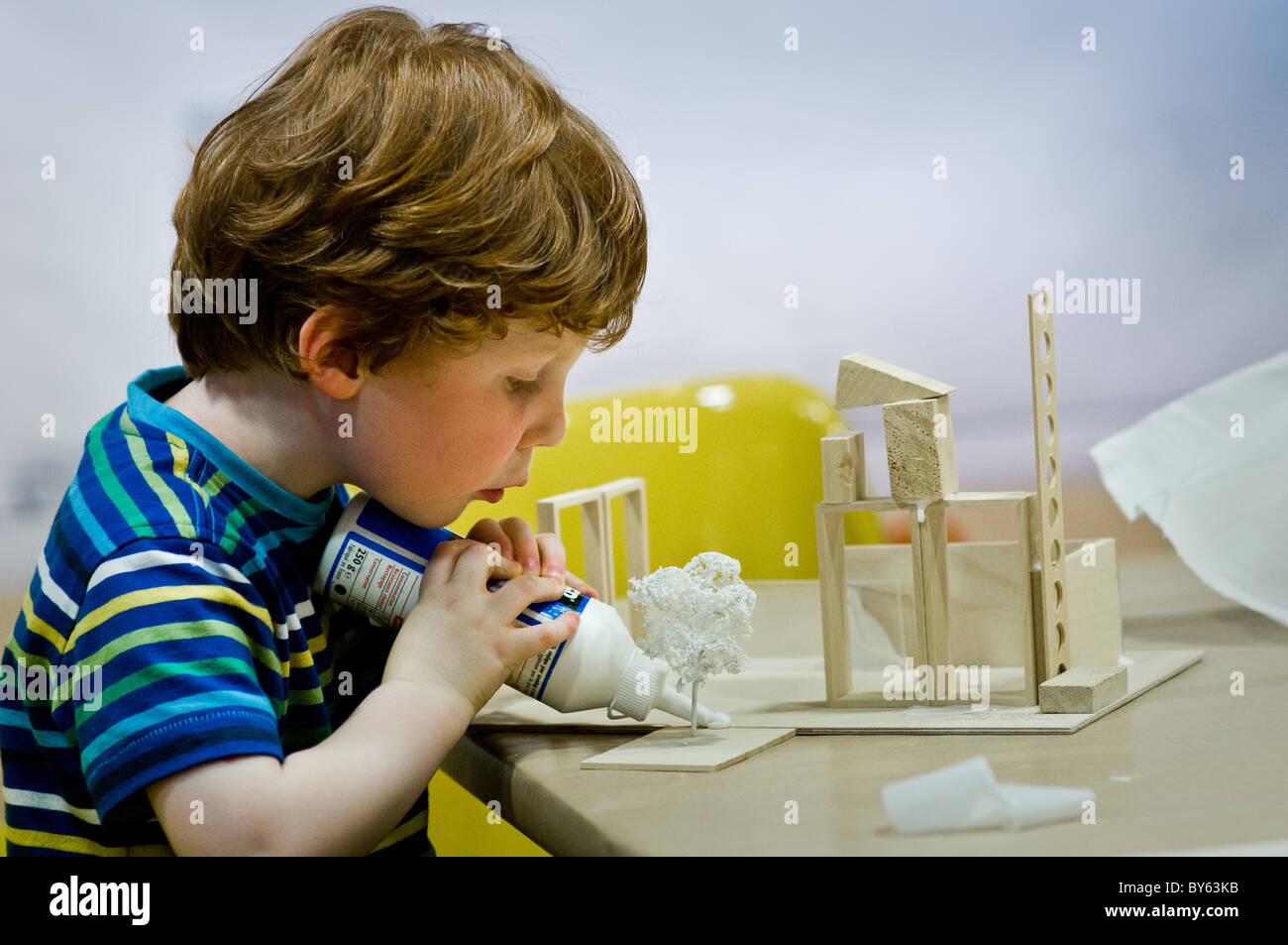 A young boy sticking a model he has made. Stock Photo