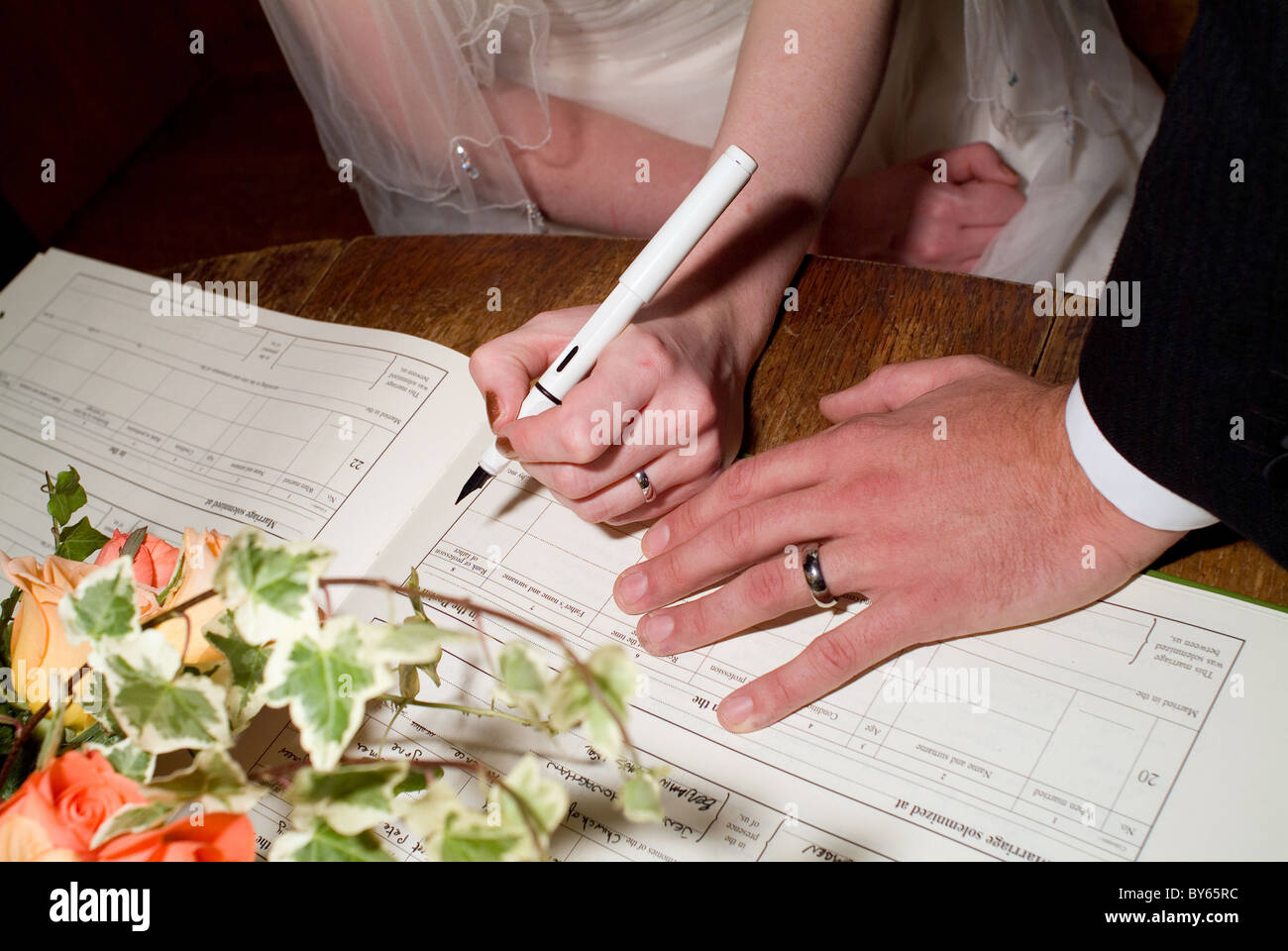 bride and groom signing register Stock Photo Alamy