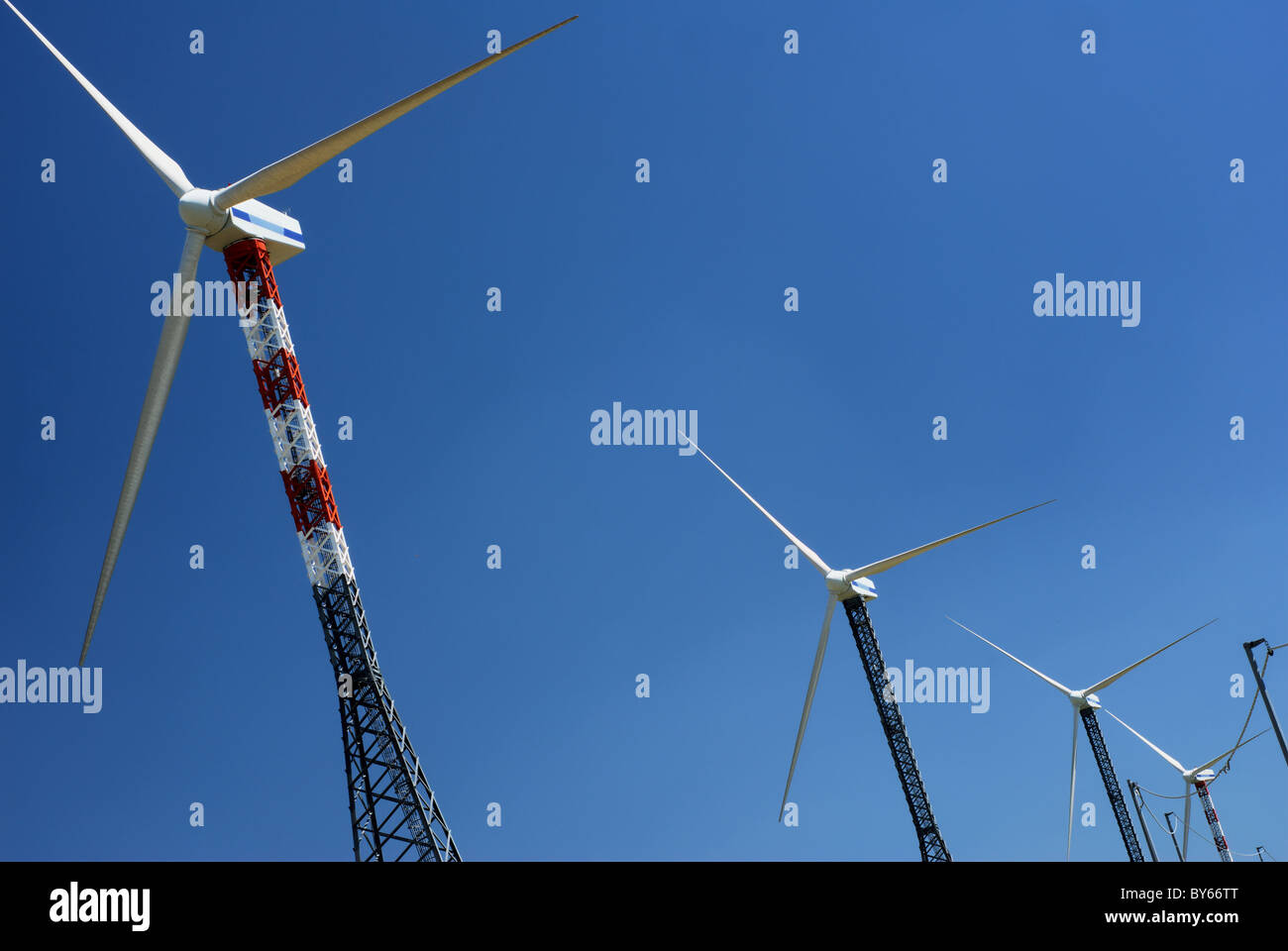 Row of windmills in blue sky Stock Photo