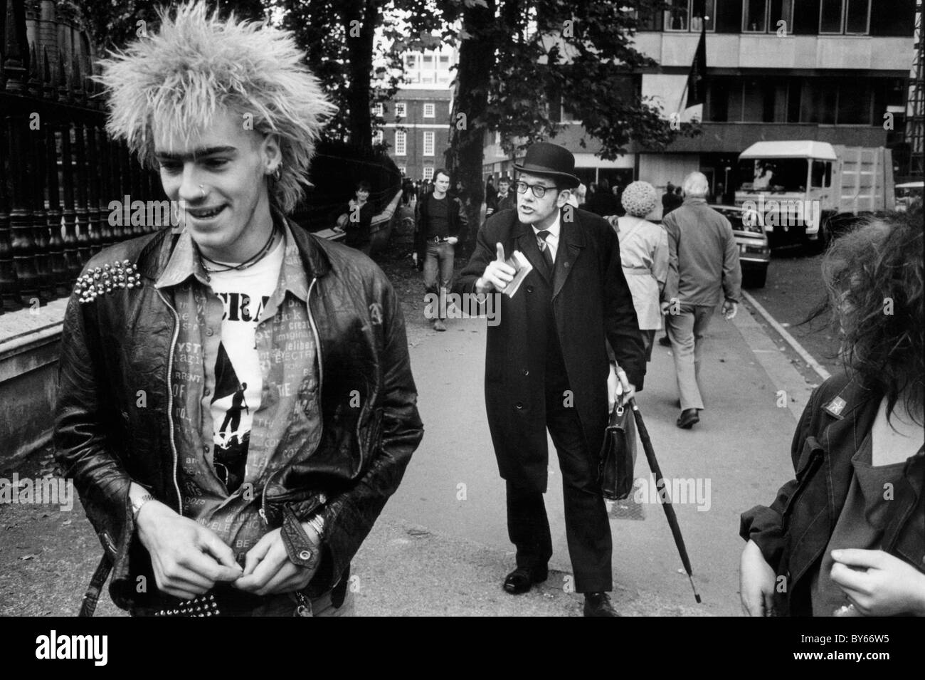 A man who appears to be a city gent scolds a punk in the street near St Paul's Cathedral London Stock Photo