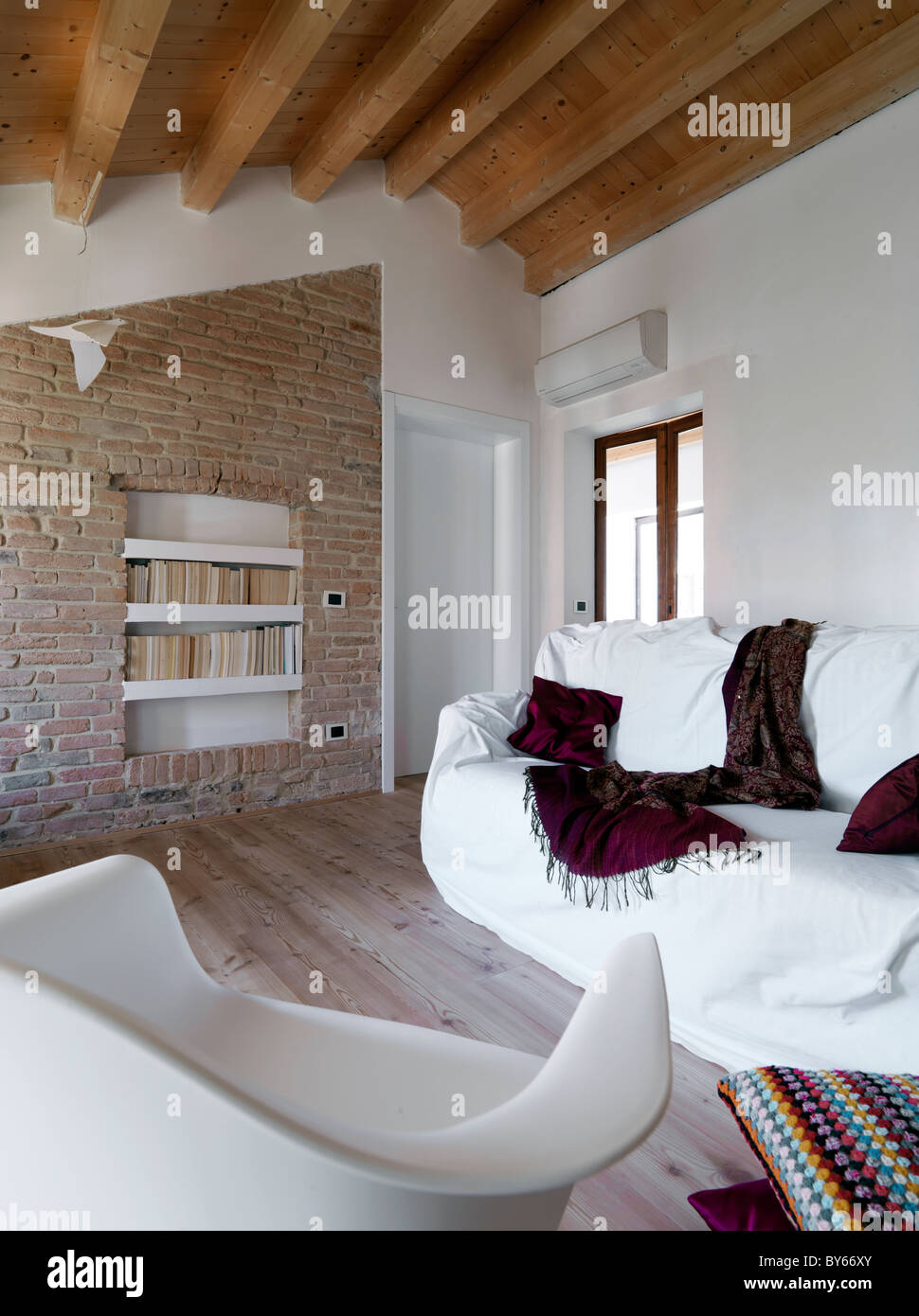 Living Room With Two White Sofa In The Mansard Wooden Beams