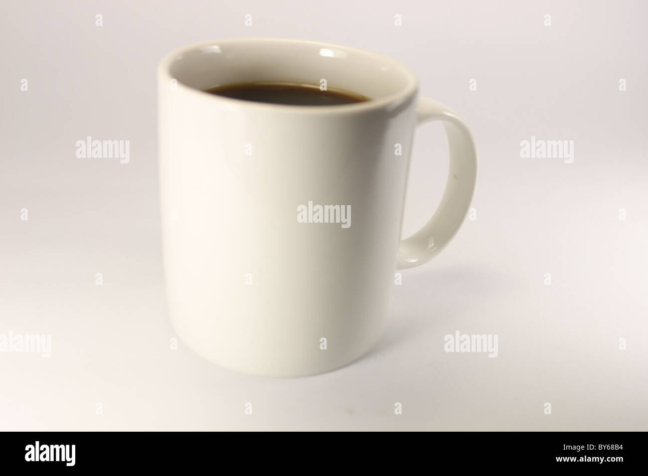 white mug with coffee on a white background with a close range Stock Photo