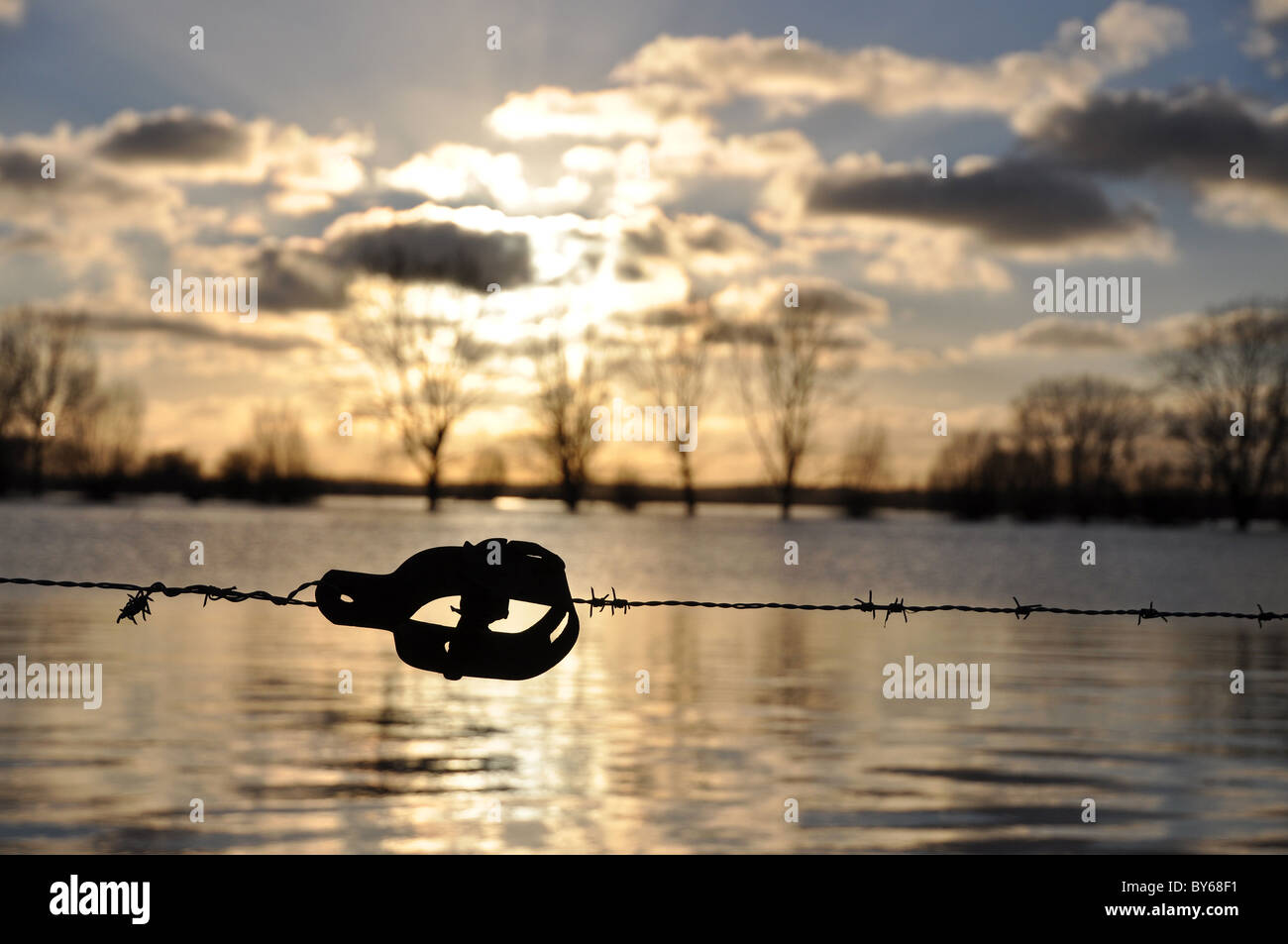Barbed wire tensioner at sunset over high waters Stock Photo Alamy