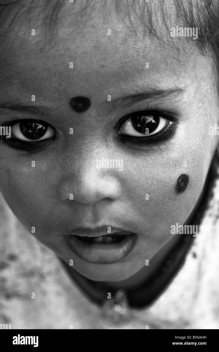 Small Indian child with kohl applied in spots to ward off 'the evil eye', South India. Kohl is an eye cosmetic. Black & White. Stock Photo