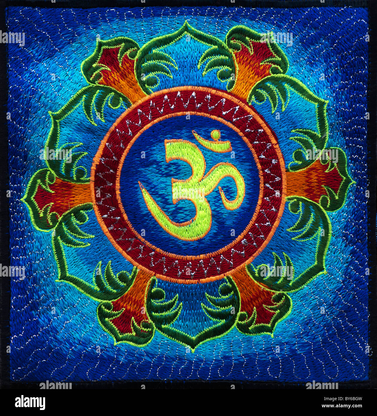 Multicoloured Hindu OM / AUM and lotus flower embroidery pattern. Indian handicraft Stock Photo