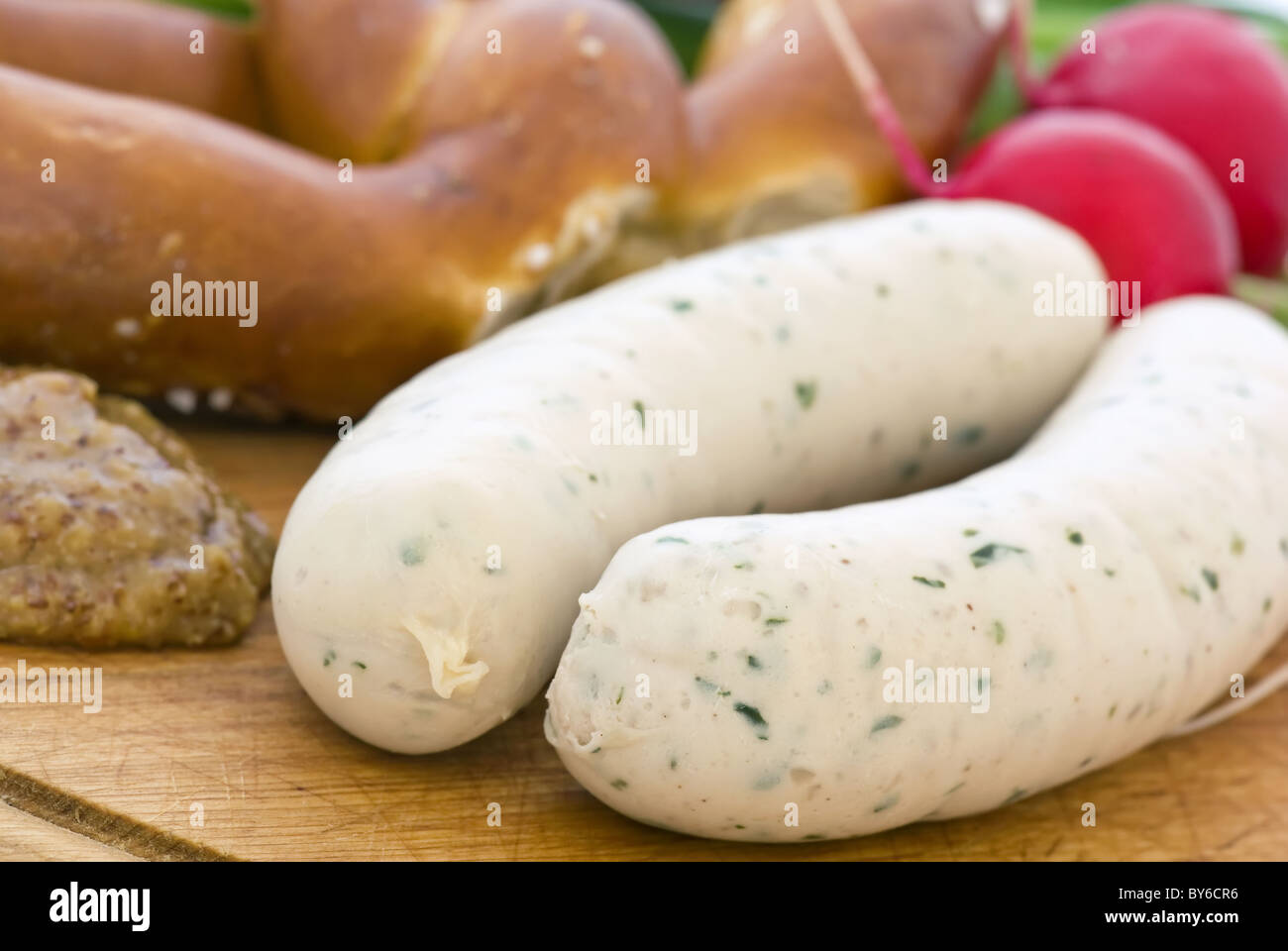 Weisswurst with Pretzel and sweet mustard  as closeup on a chopping board Stock Photo