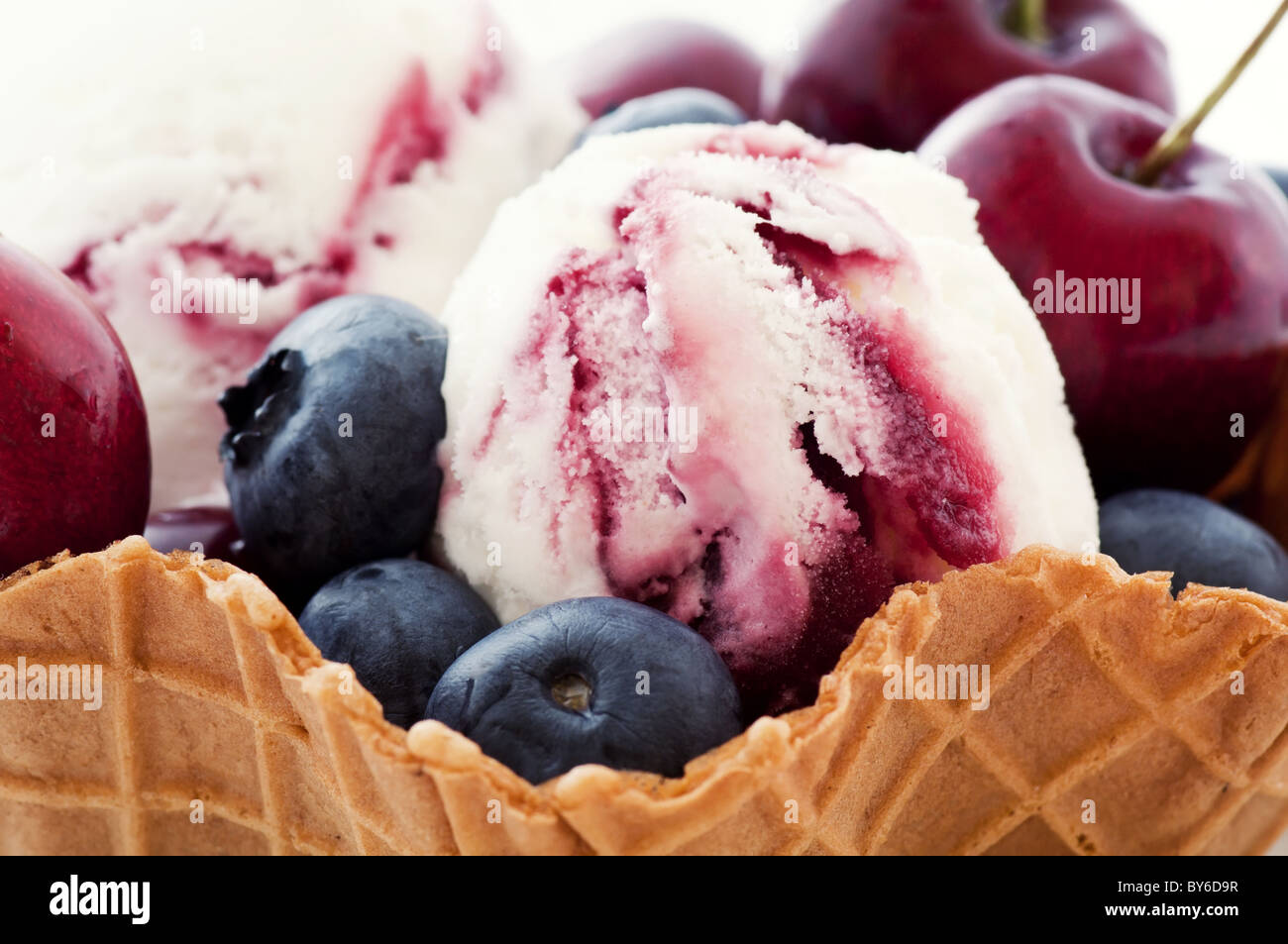 Scoop of ice cream with fresh fruits as closeup in a waffle bowl Stock Photo