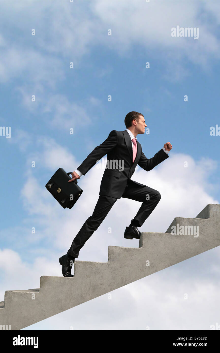 Image of confident businessman with briefcase walking upstairs Stock Photo