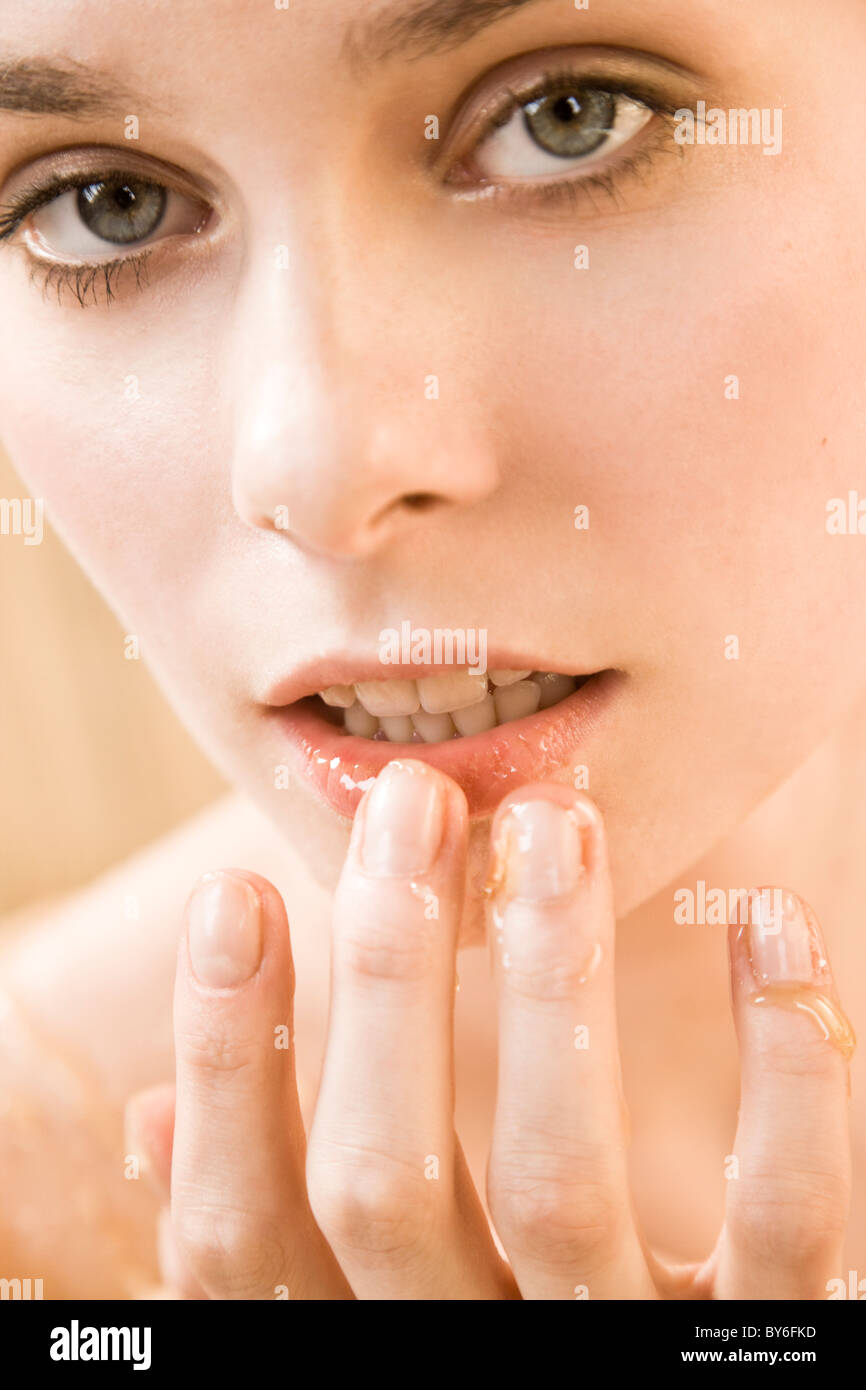 Woman applying honey on lips Stock Photo Alamy