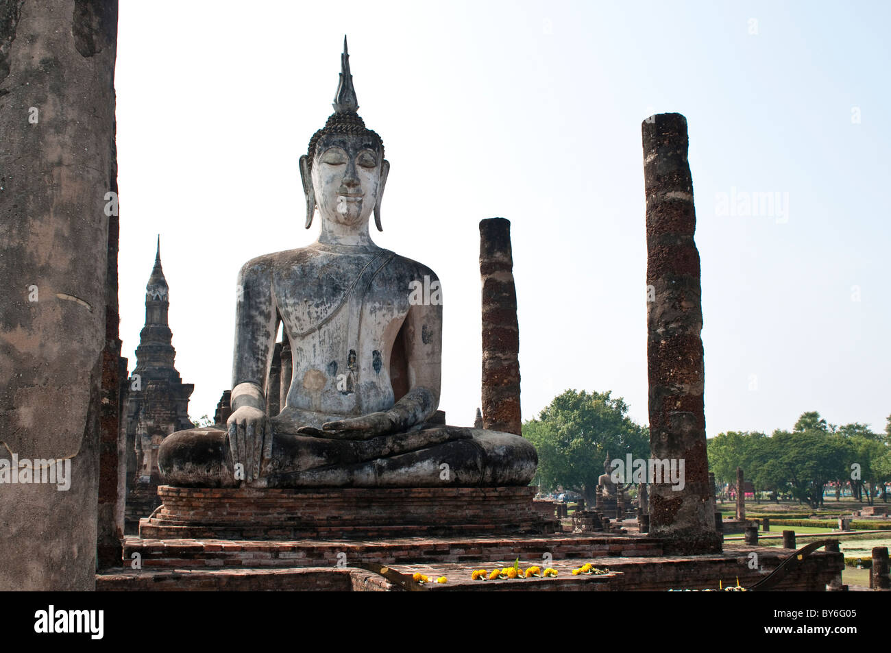 Flower offerings at Buddha shrine, Wat Mahathat, Sukhothai Historical Park, Thailand Stock Photo