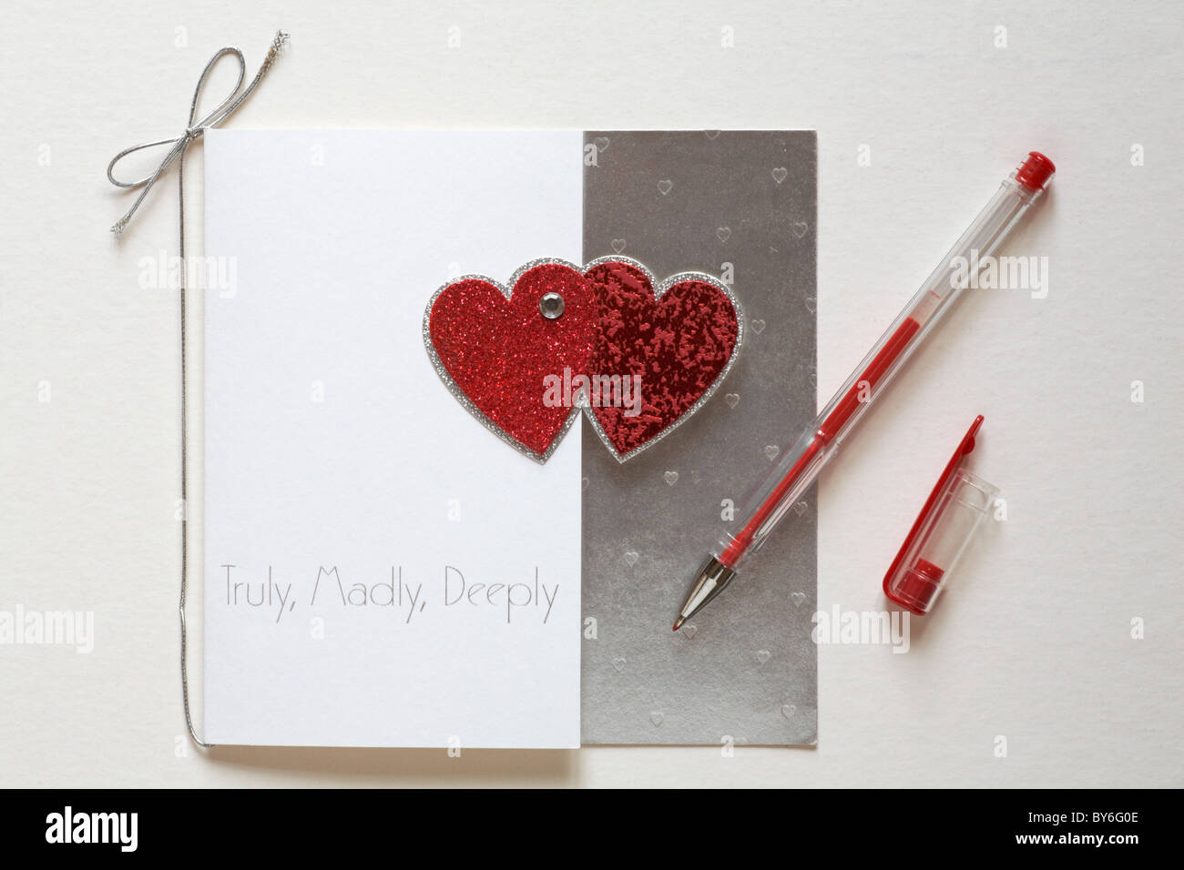 Truly, Madly, Deeply valentine card with red pen getting ready to write for Valentines day Stock Photo