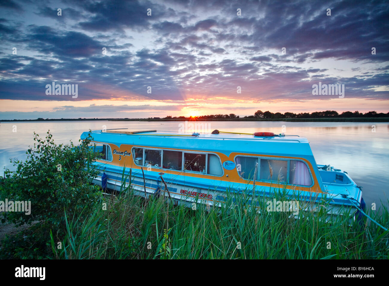 Norfolk Broads holiday cruiser moored up on Horsey Mere at sunset on the Norfolk Broads Stock Photo