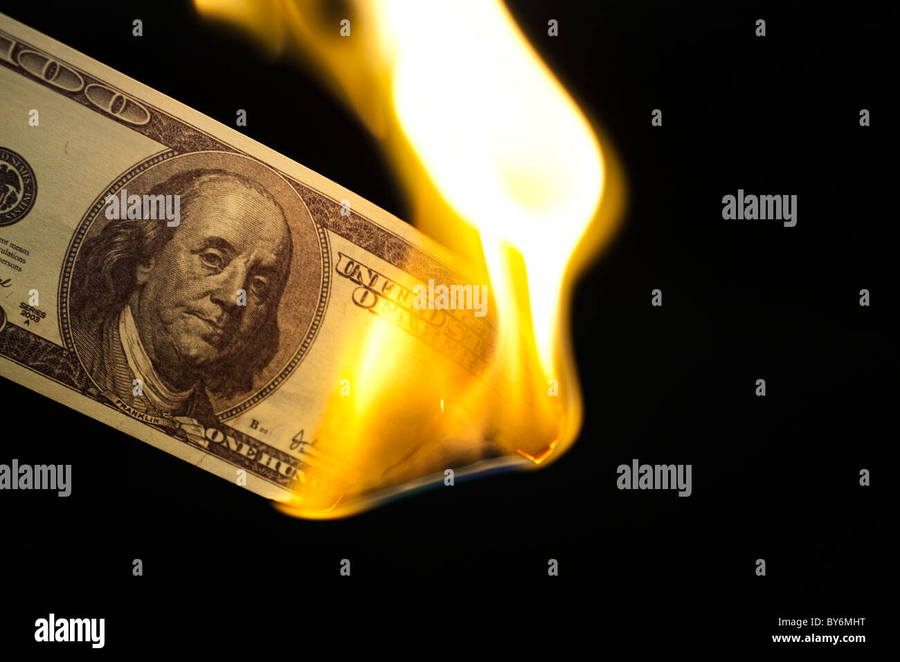 Image of one hundred bill burning on black background Stock Photo