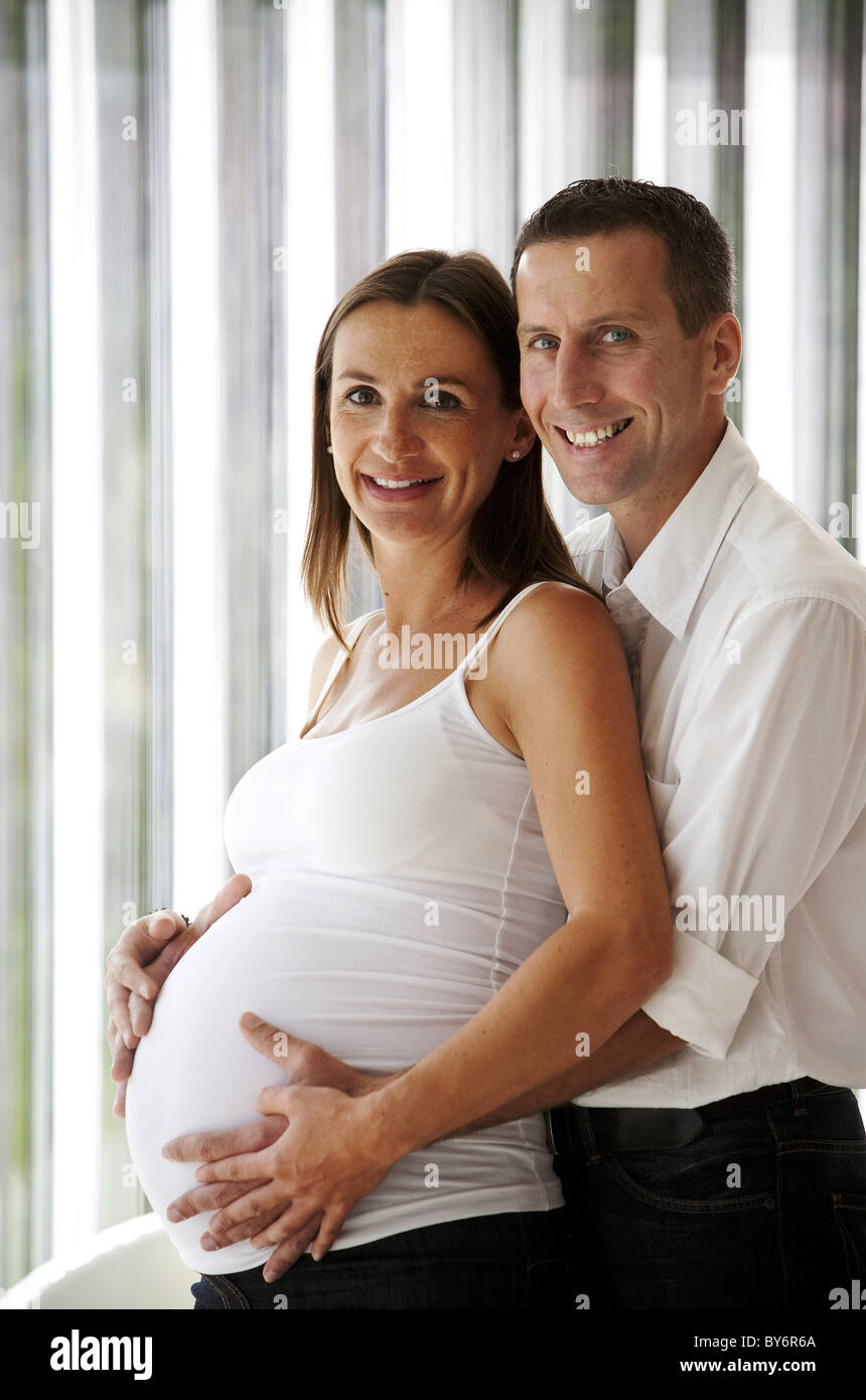 Man embracing pregnant woman Stock Photo - Alamy