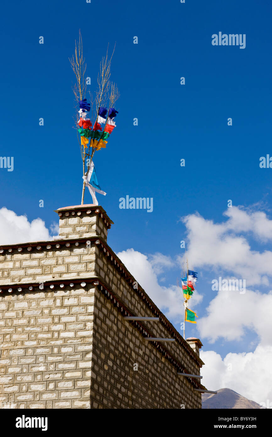 Traditional flags on roof of house in Tibetan village on the road from Lhasa Airport at Gonggar to Lhasa Tibet China. JMH4418 Stock Photo