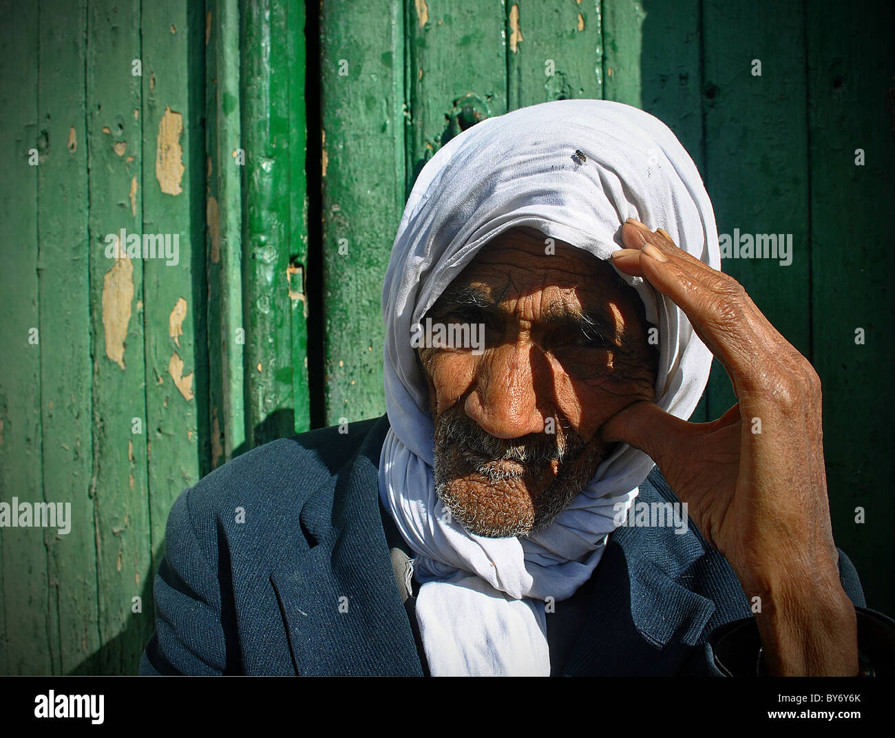 Elderly Tunisian man sitting in doorway, Tozeur, Tunisia Stock Photo