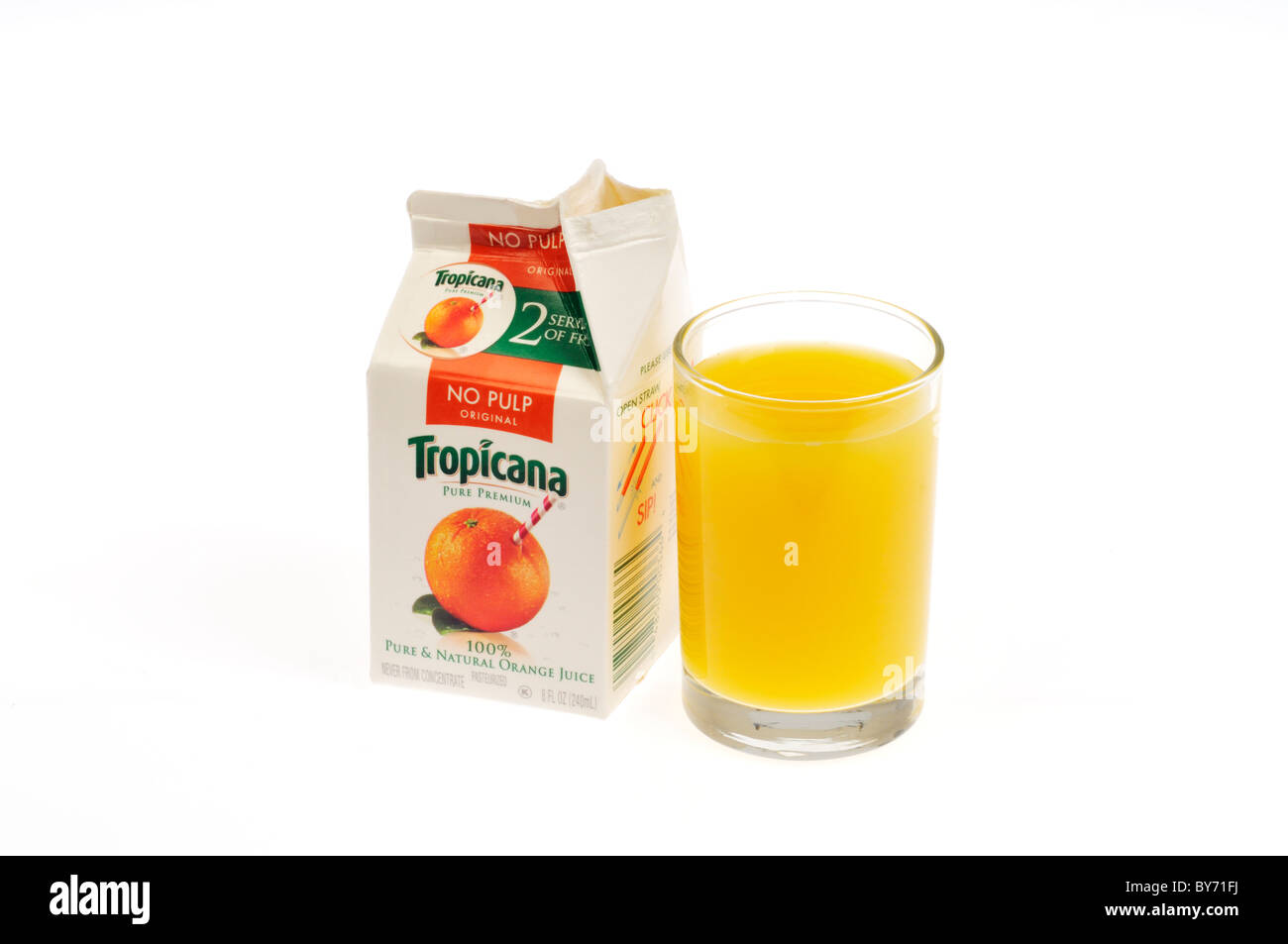 Poured glass of Tropicana orange juice with open carton on white background, cutout. Stock Photo