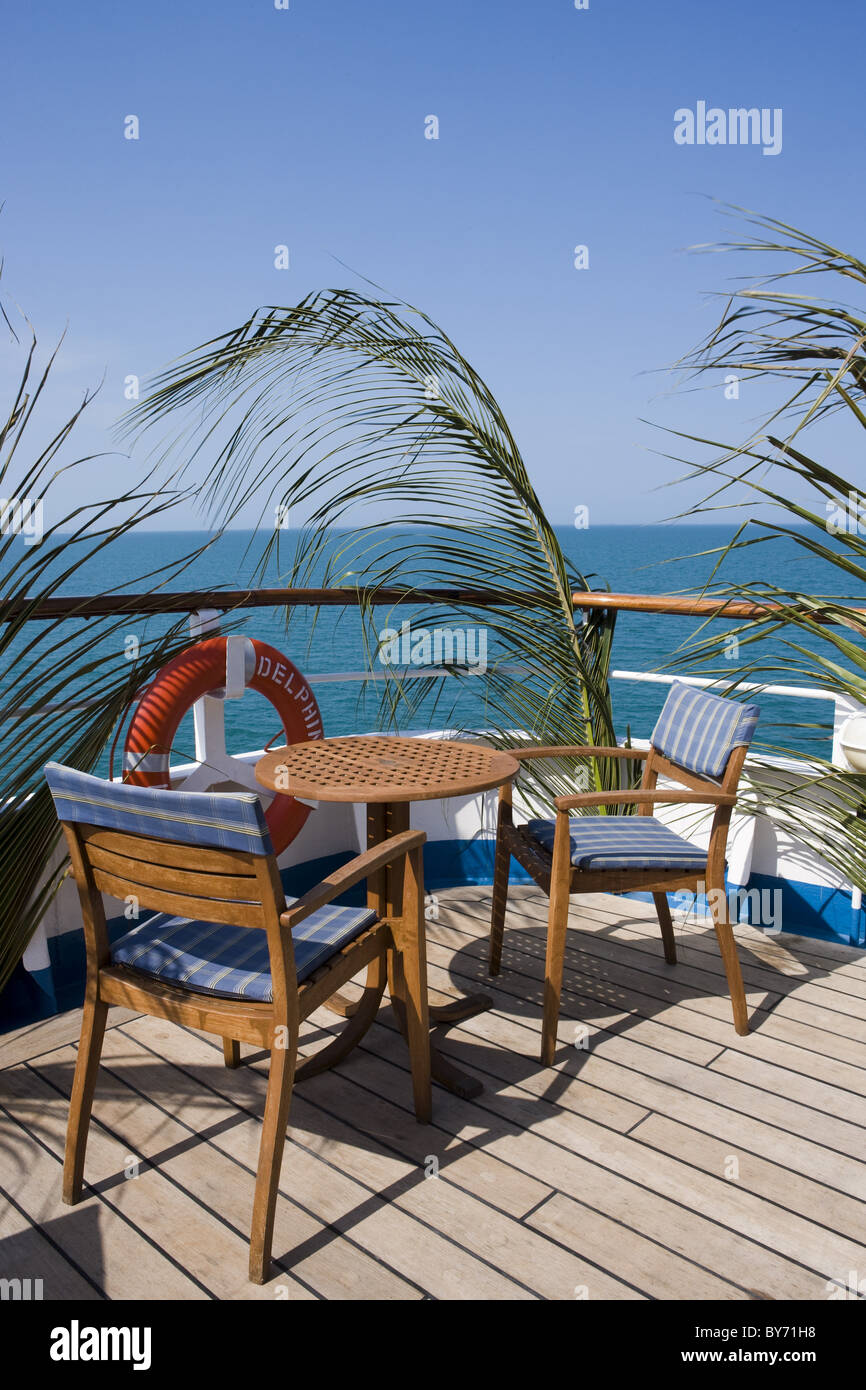 Palm fronds on railing and deck chairs and table aboard Cruiseship MS
