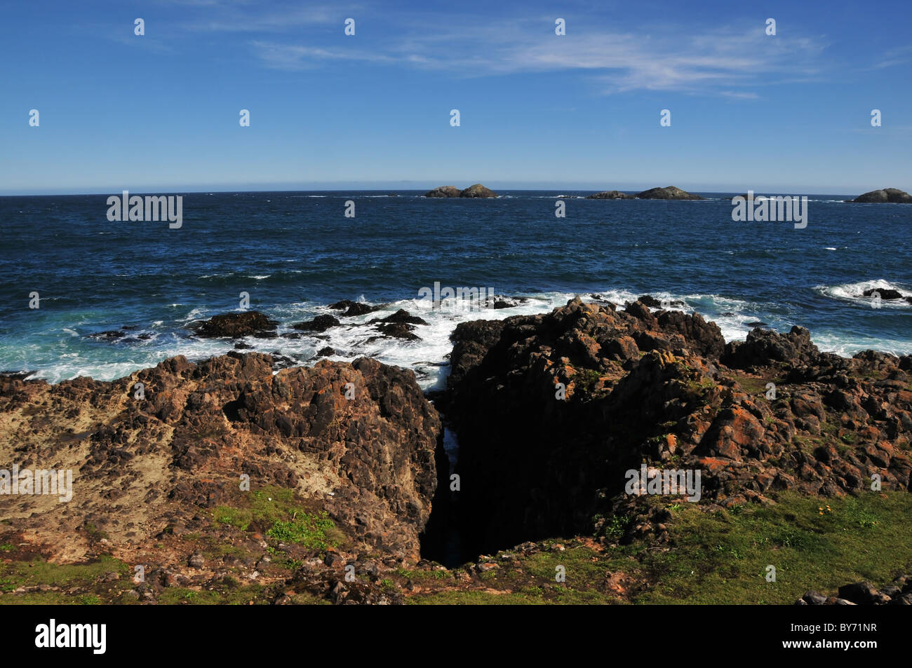 Blue sky view, looking out to sea, of a collapsed cave 'geo' in the ...