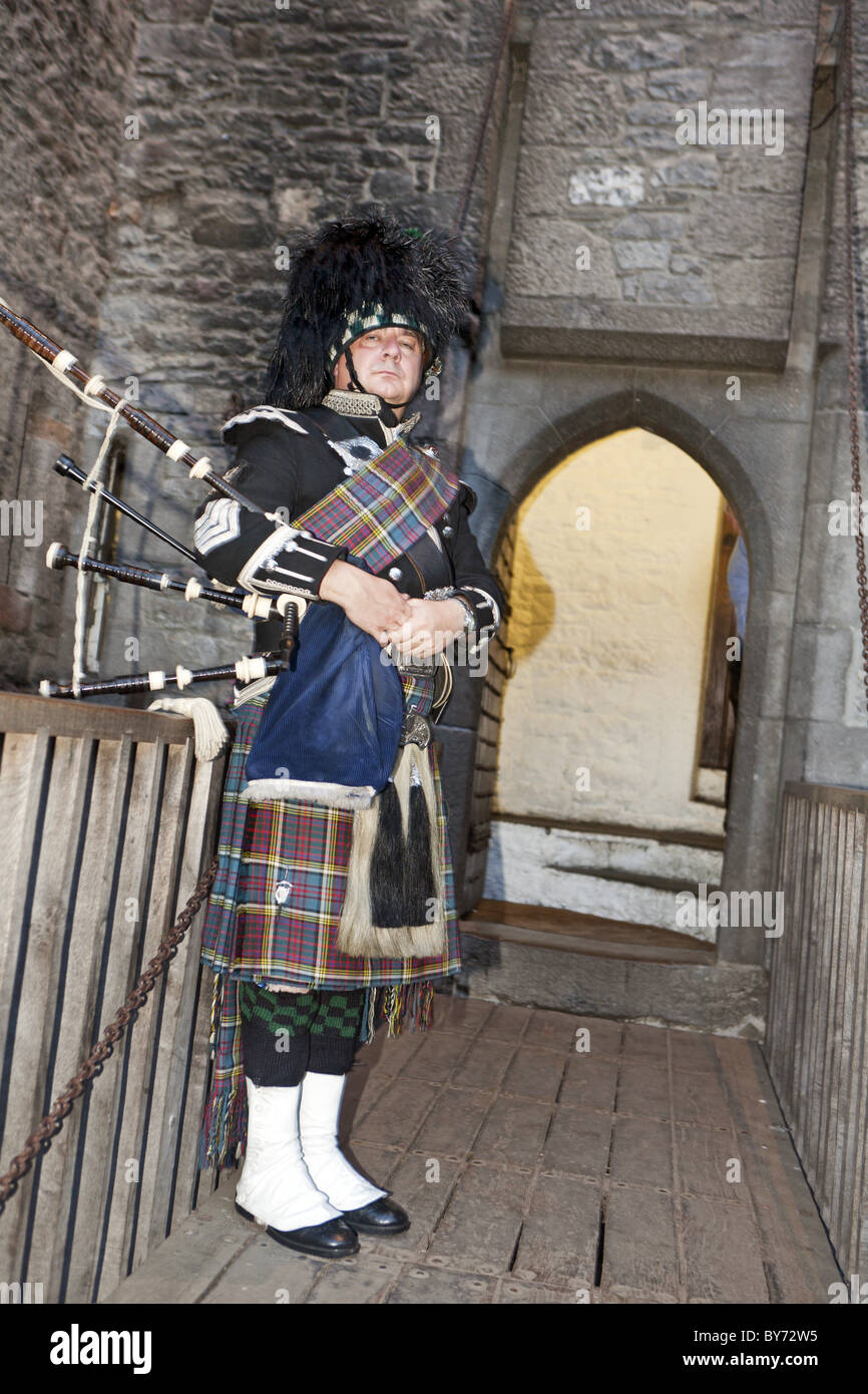 Bagpiper in front of the entrance to Bunratty Castle, County Clare, Ireland Stock Photo