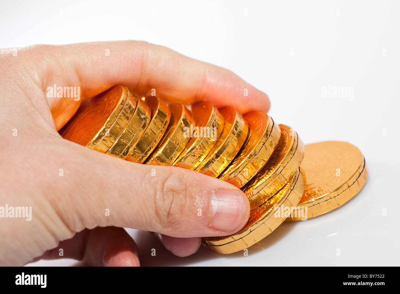 mankind counting the coins made of chocolate on the table Stock Photo