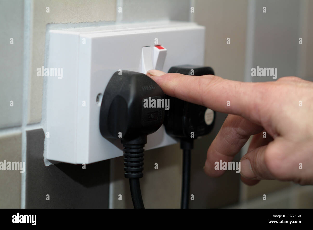 Someone switching on an electrical socket Stock Photo