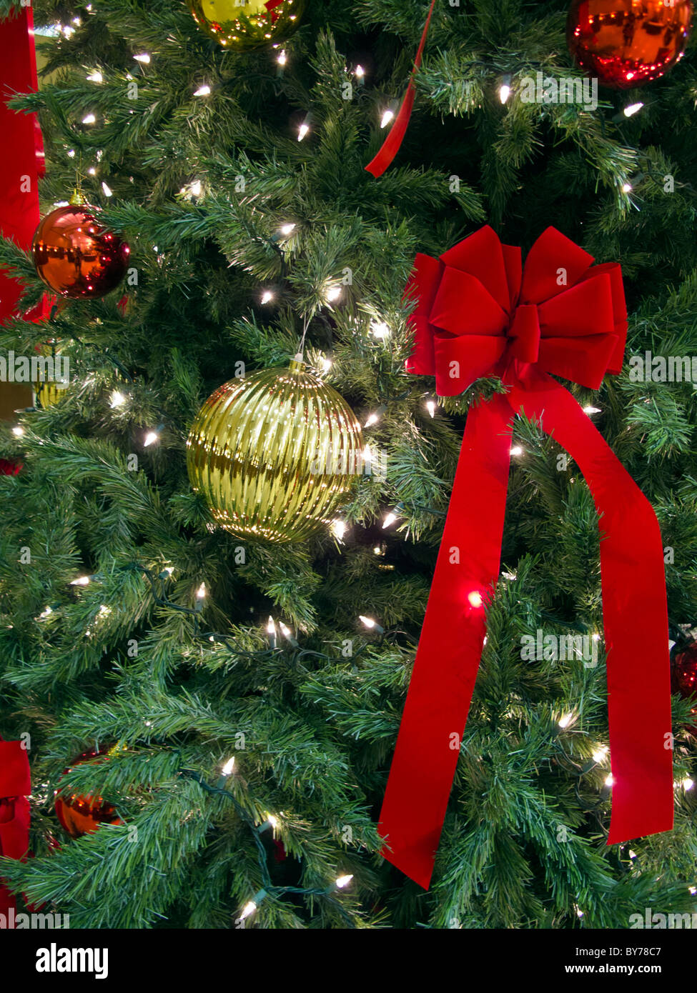 Decorated Christmas tree with large ornaments and red bow Stock Photo