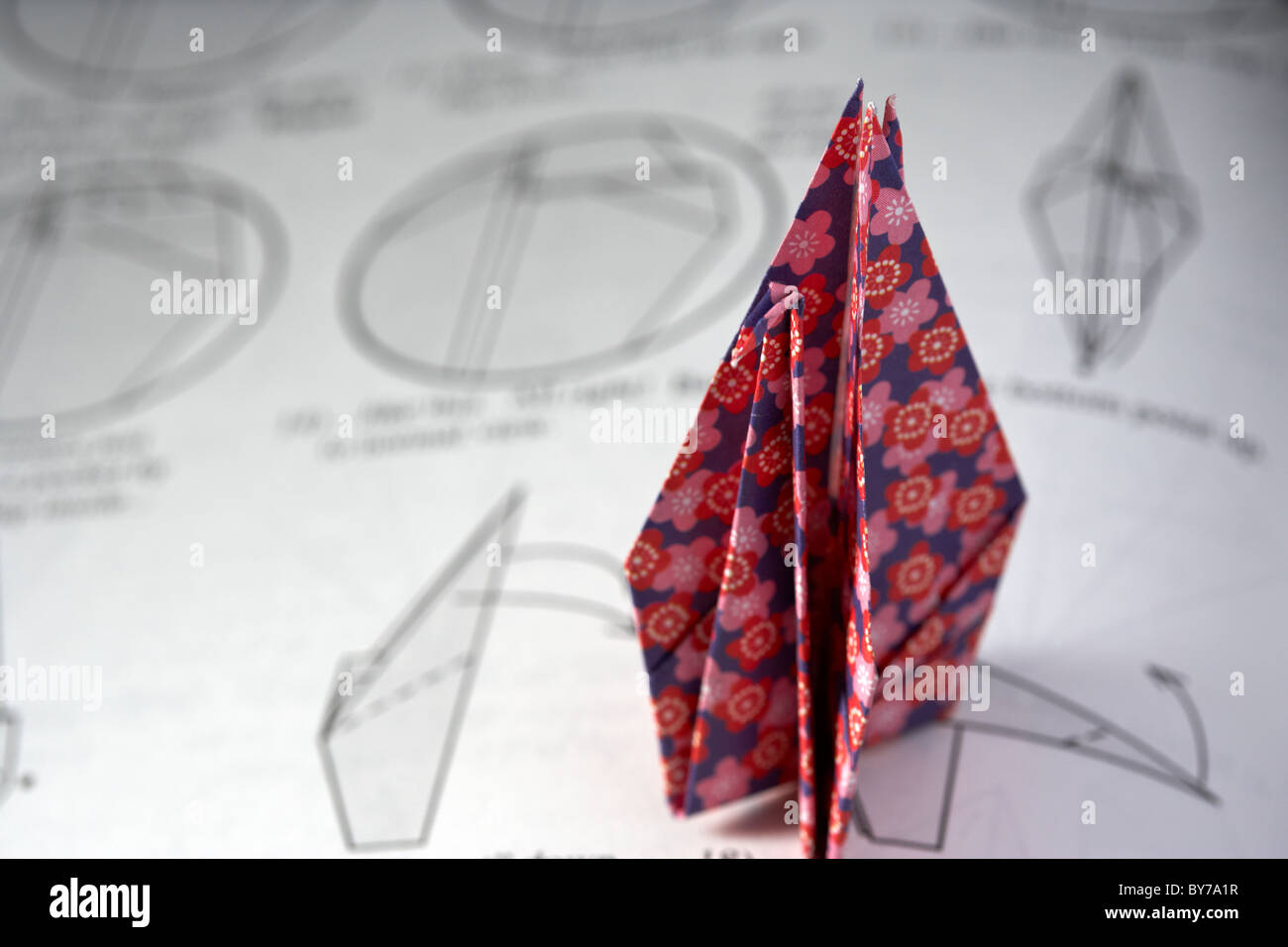 origami swan folded on instruction book Stock Photo
