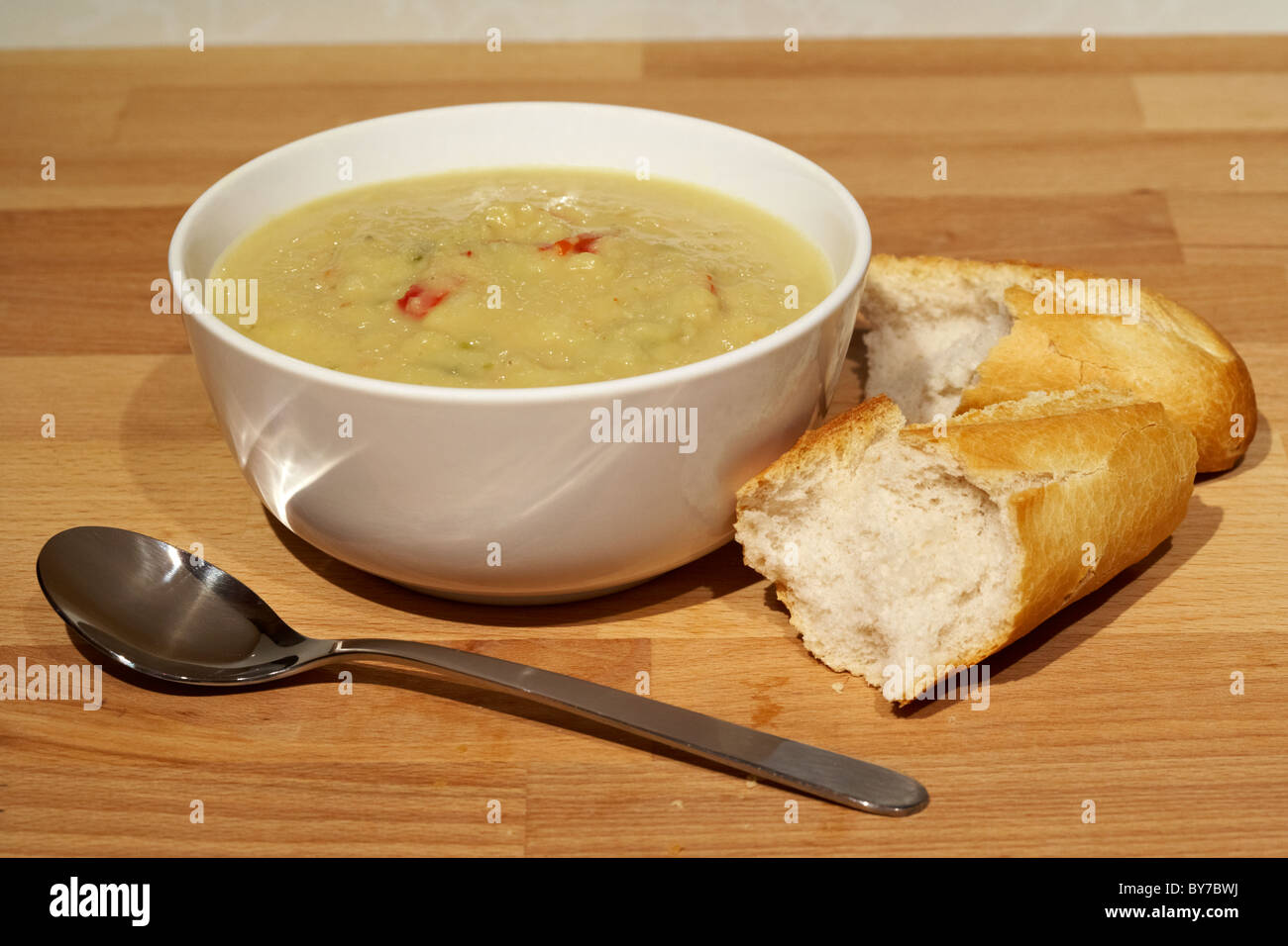 bowl of homemade lentil and pepper soup with crusty bread and spoon Stock Photo