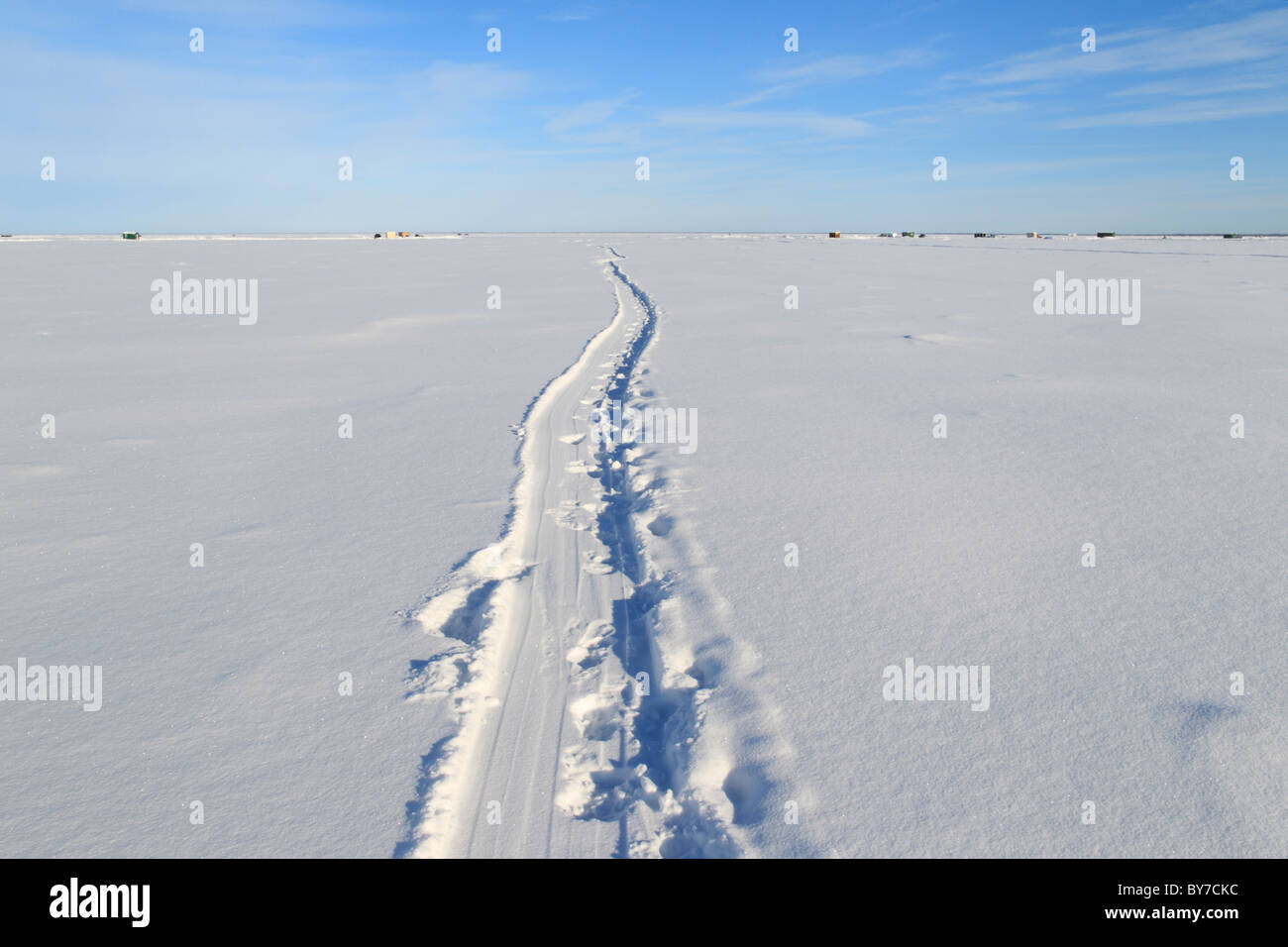 A trail leading to some distant ice fishing houses on Red Lake in Northern Minnesota Stock Photo