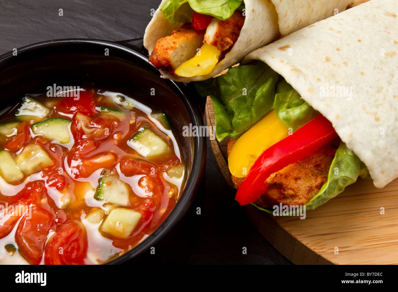 Spicy chicken wrap and pot of vibrant salsa. Stock Photo