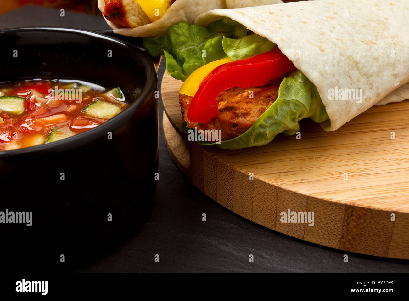 Spicy chicken wrap and pot of vibrant salsa. Stock Photo