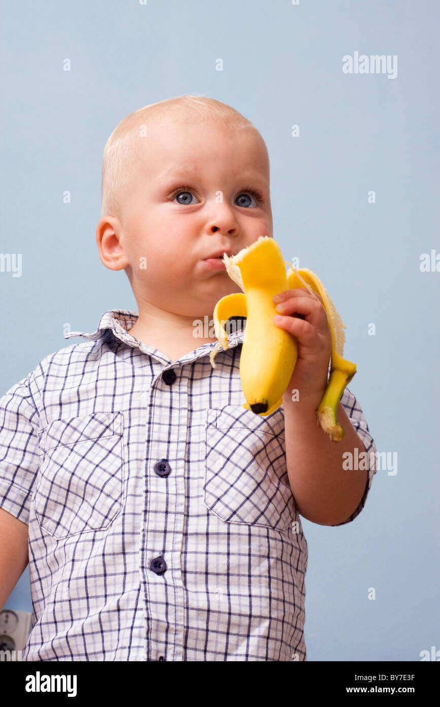 Baby boy, 1 year, with banana Stock Photo