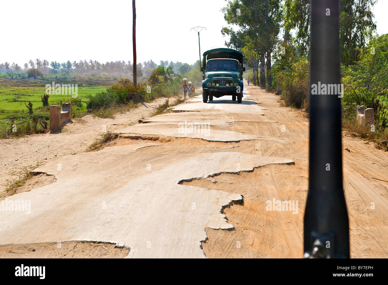 A truck on the dilapidated tar road leading out of the town of Morondava on the southwestern coast of Madagascar. Stock Photo