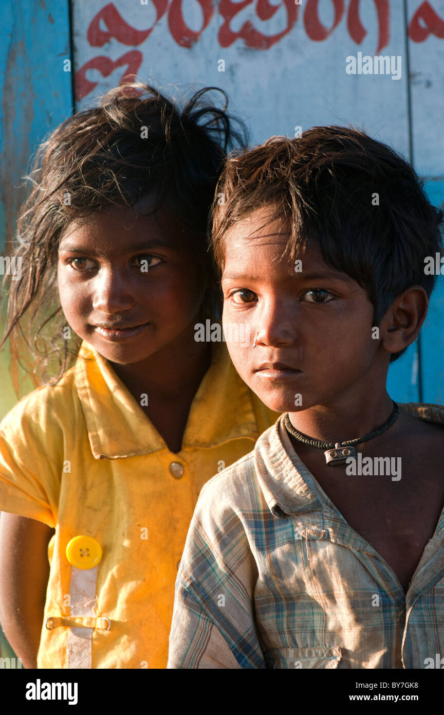 Happy young Indian lower caste street boy and girl in strong sunlight