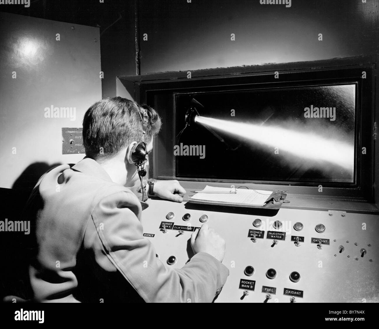 An engineer operating a rig used for studying film-cooling of combustors. 1952 Stock Photo